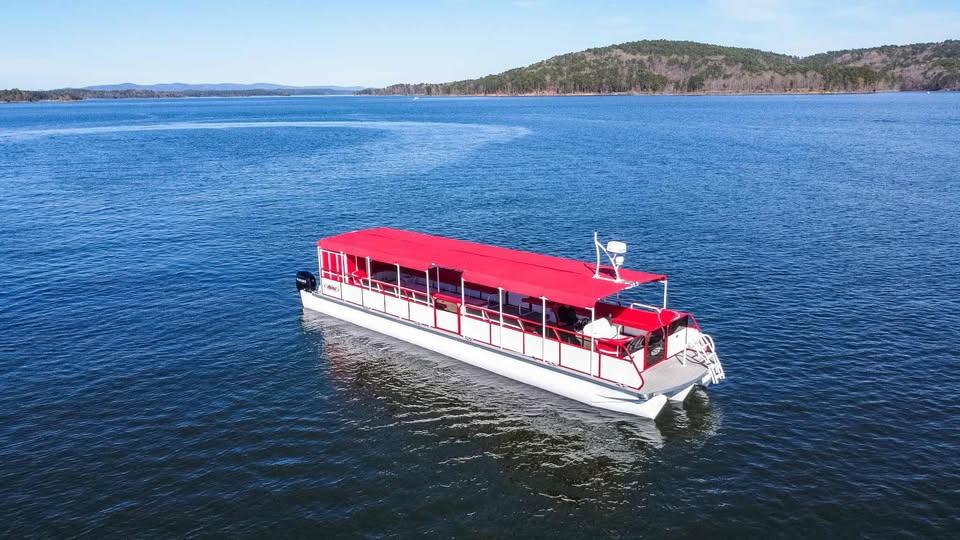 2024 Aloha Pontoon 50' Water Taxi with red canopy on a serene lake.