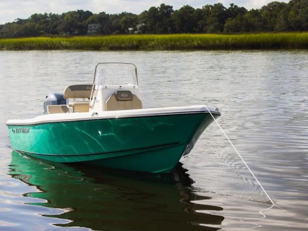 2025 Key West 179 FS boat on calm water, green hull, anchored near shoreline.