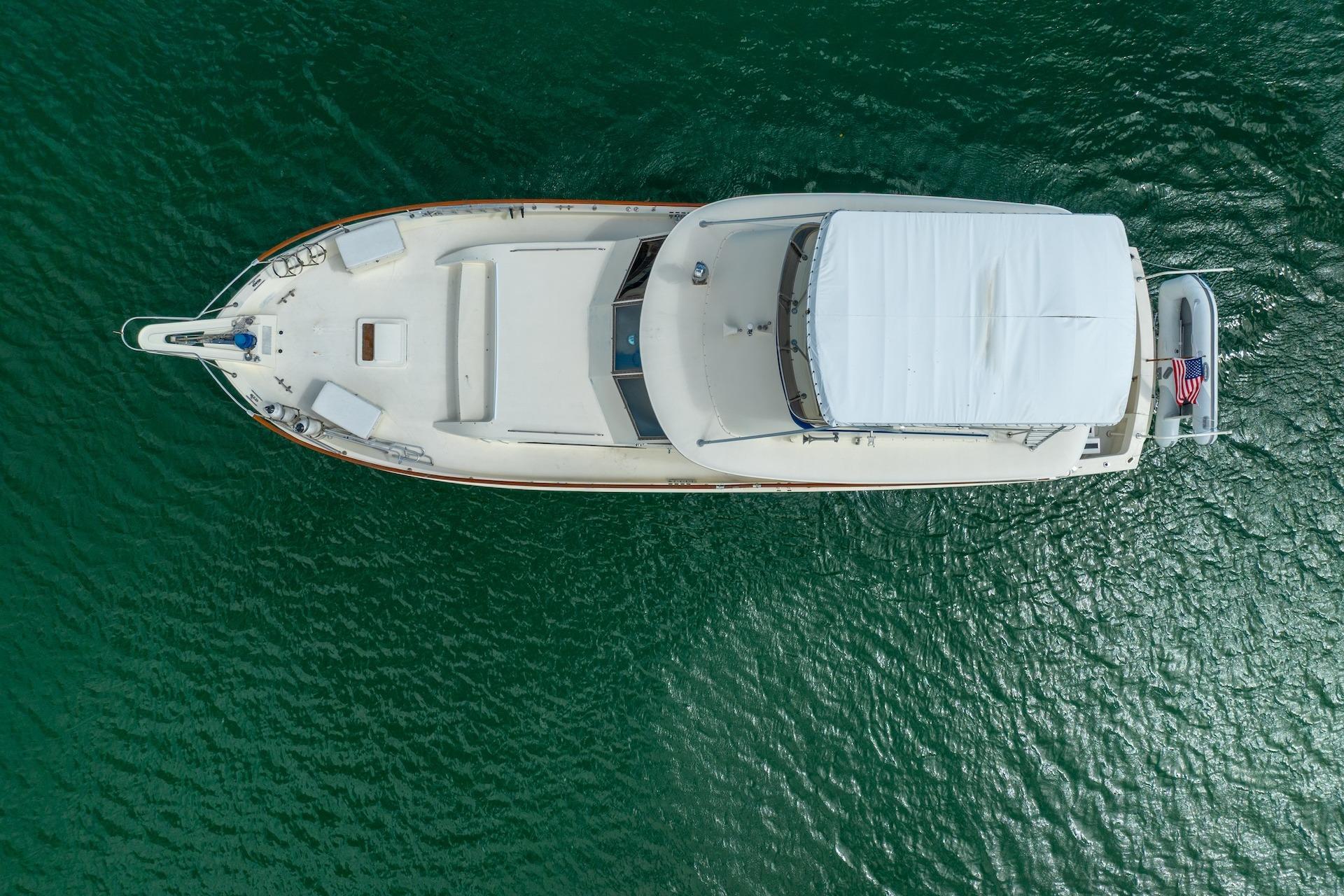 Overhead view of a 1978 Hatteras 53 Yacht Fisherman on calm green water.