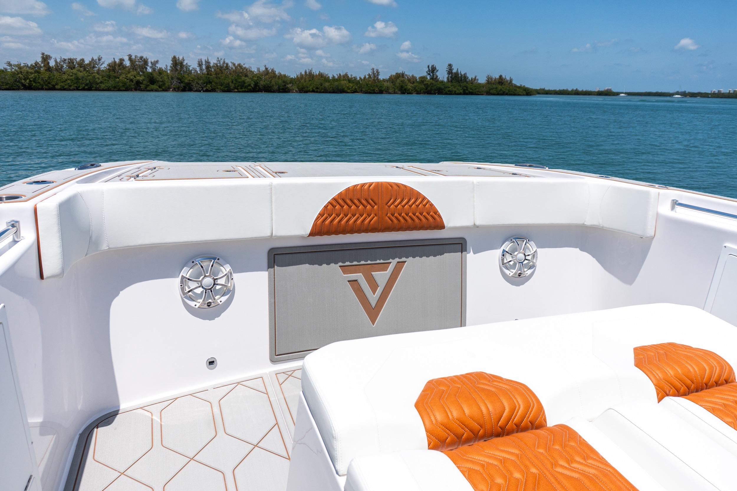 2026 Twin Vee 400 GFX2 CC boat interior with orange accents, on a serene water backdrop.