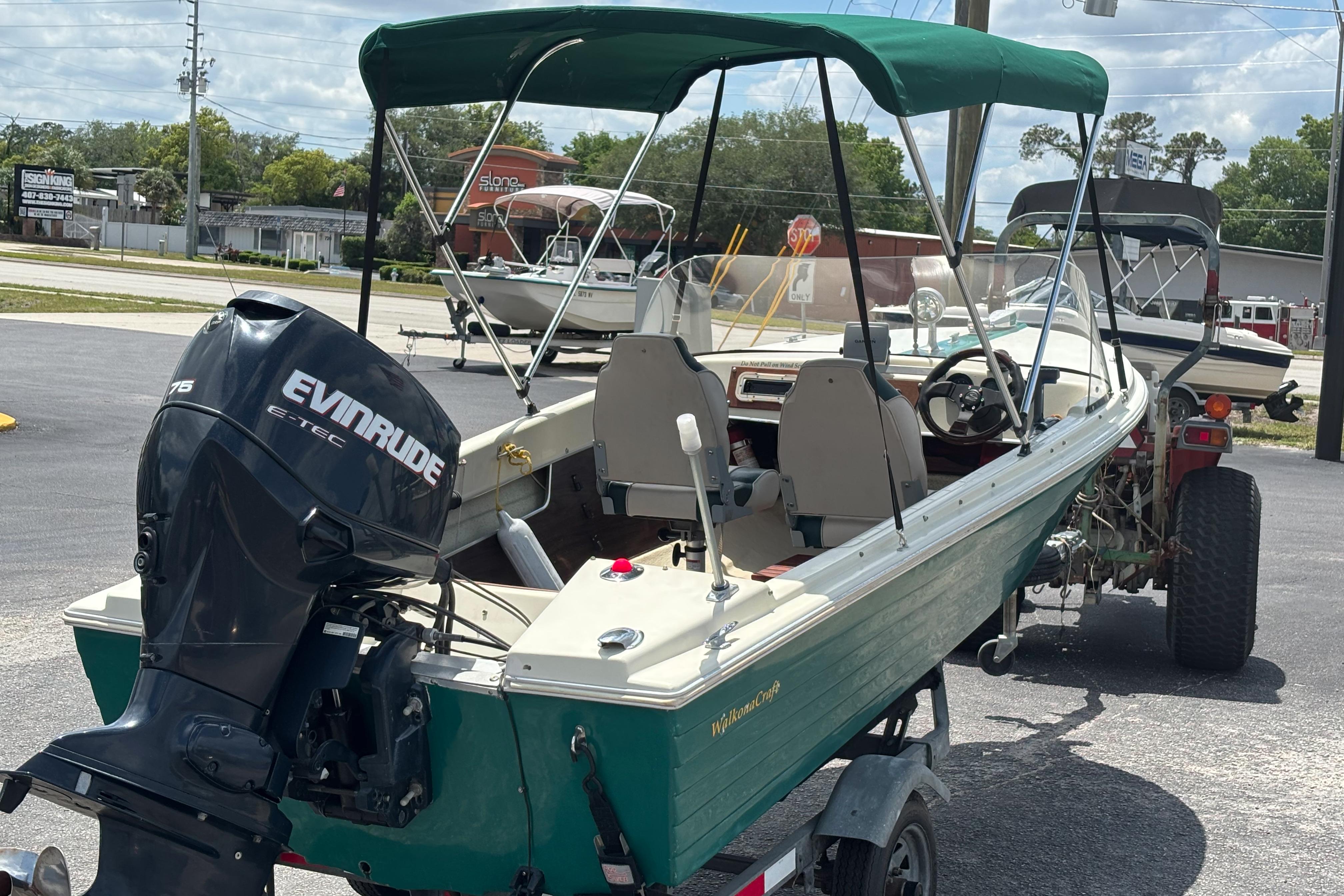 1966 Mohawk 15 boat with Evinrude motor, parked on a trailer in a lot.