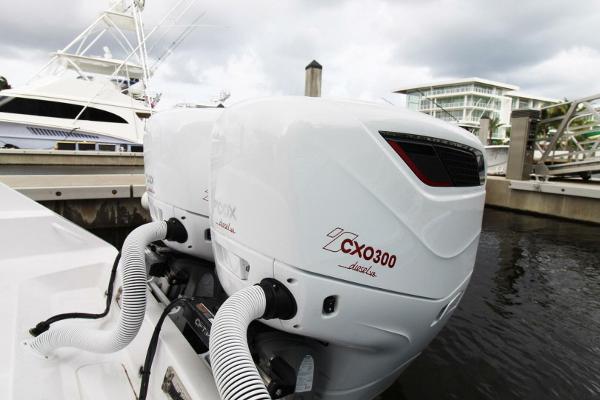 Twin CXO300 outboard engines on a 2024 Jupiter 34 HFS boat docked at a marina.