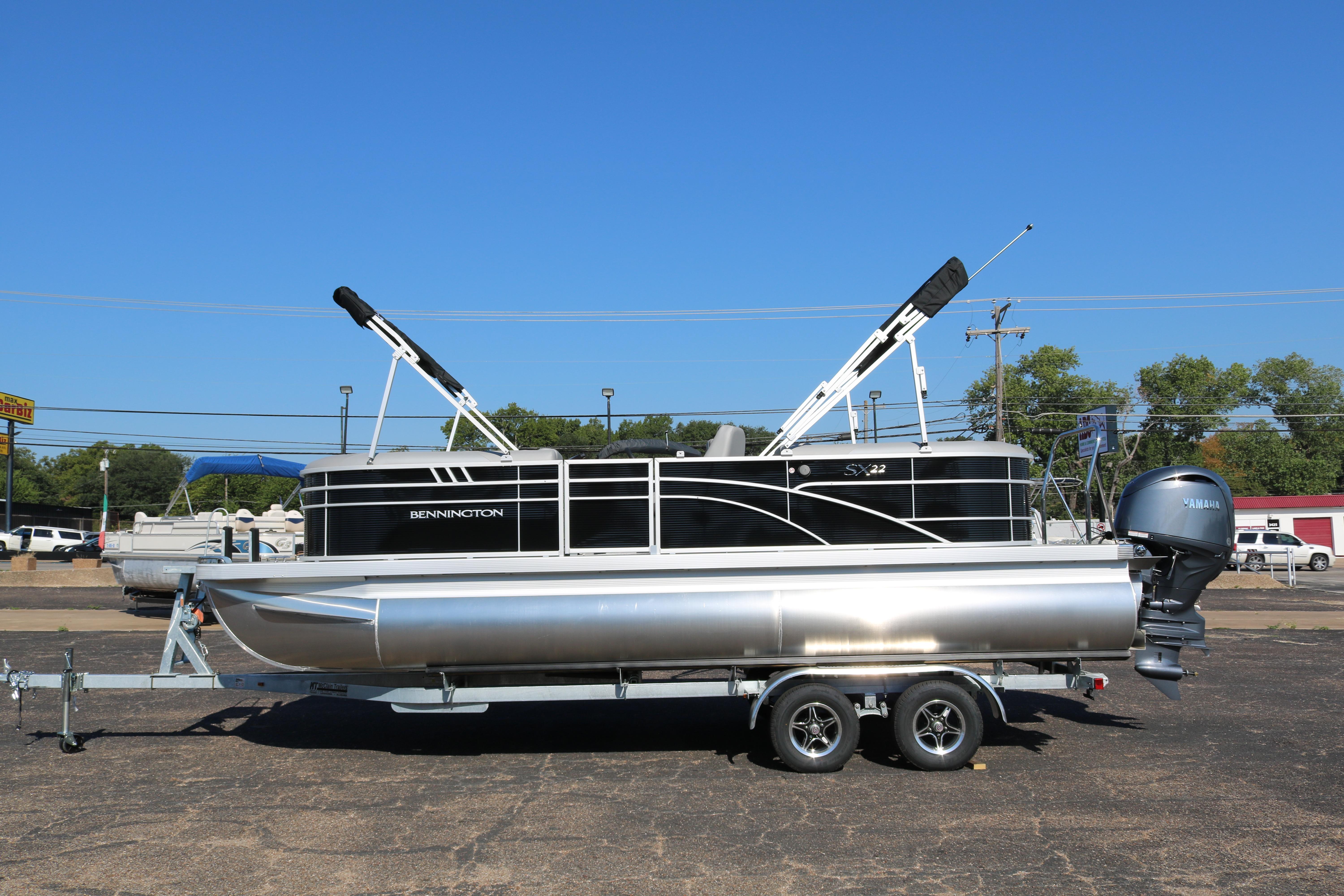 2026 Bennington 22SX Stern Radius pontoon boat on trailer, clear blue sky background.