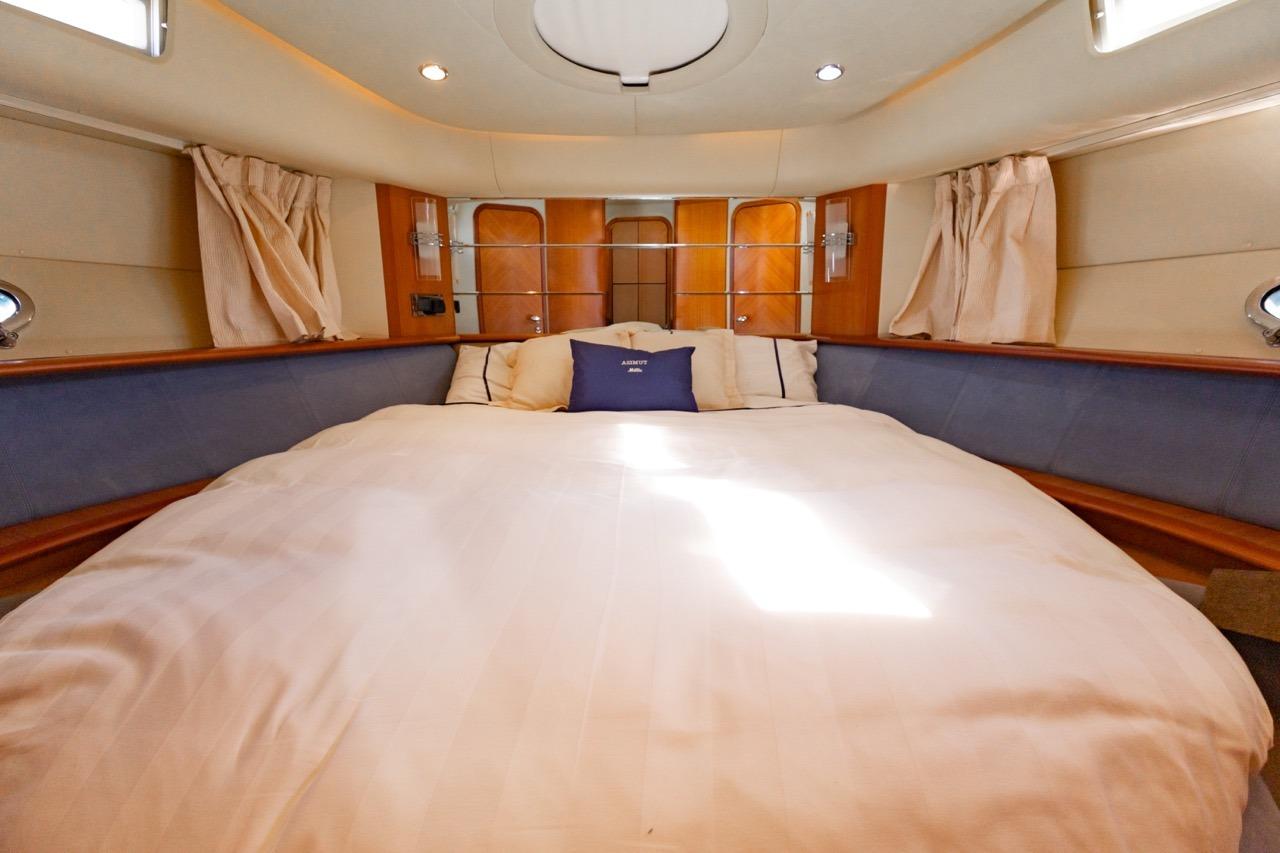 Luxurious bedroom interior of a 2005 Azimut 46 yacht, featuring a spacious bed and elegant decor.