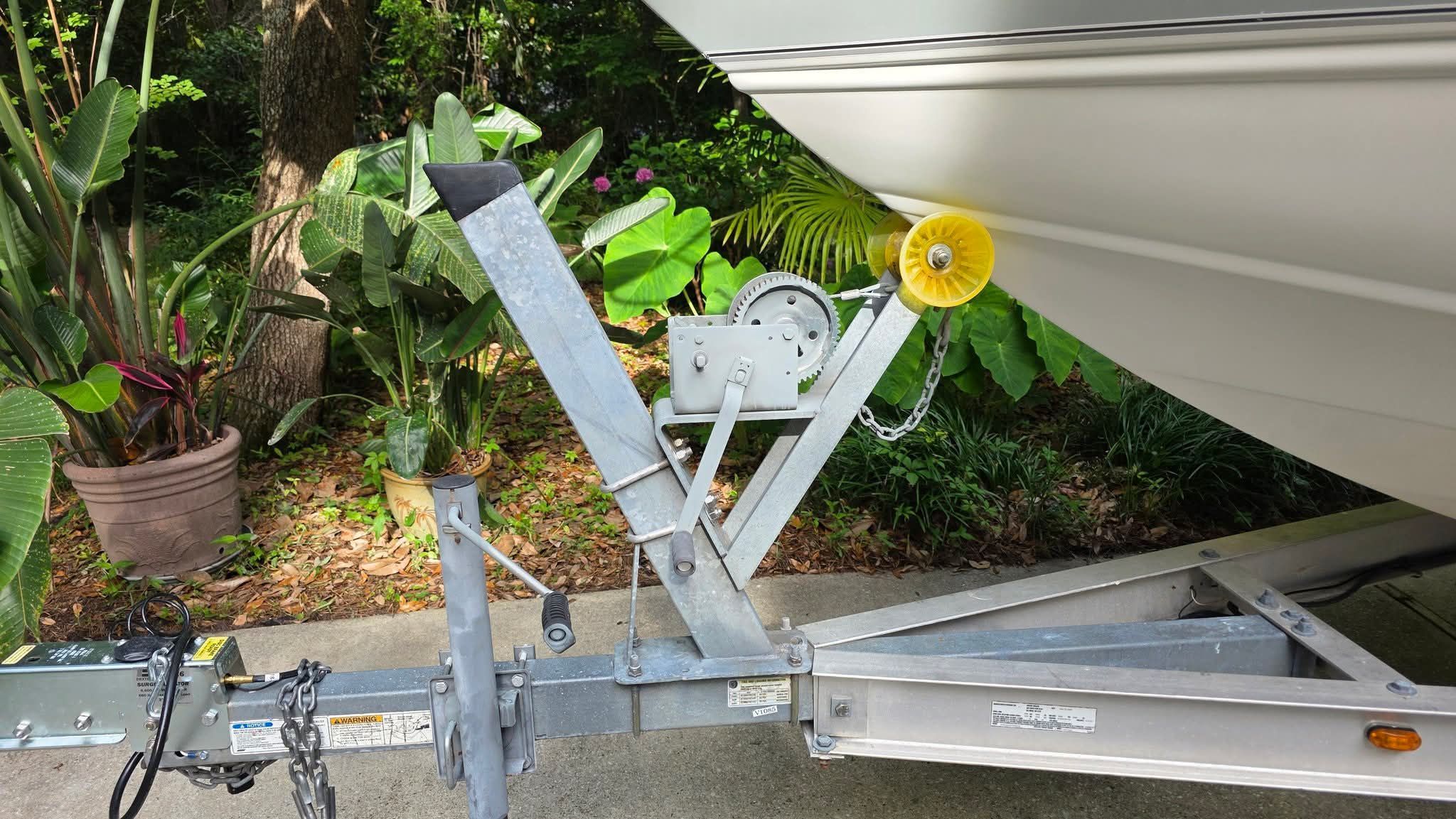 A boat on a trailer surrounded by lush vegetation.