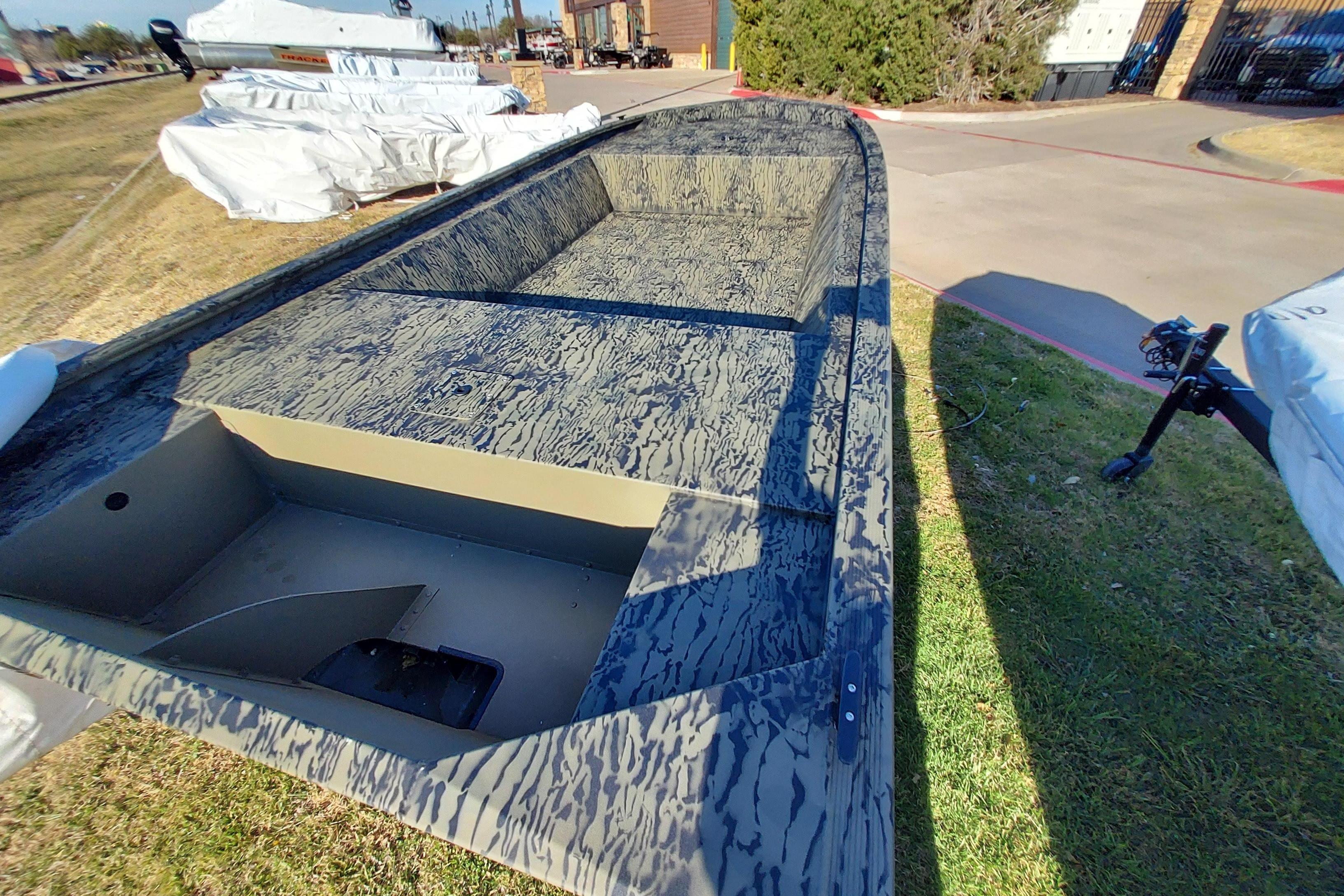 2026 Tracker Grizzly 1648 Utility boat with camouflage design on display outdoors.