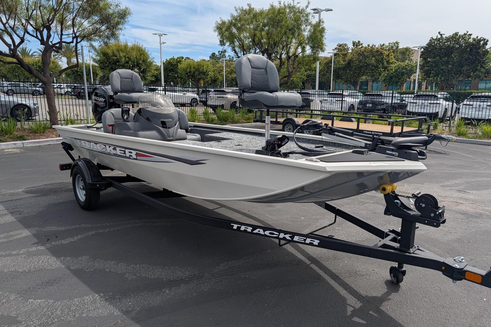 2026 Tracker Pro 170 boat on trailer in parking lot, featuring dual seats and motor.