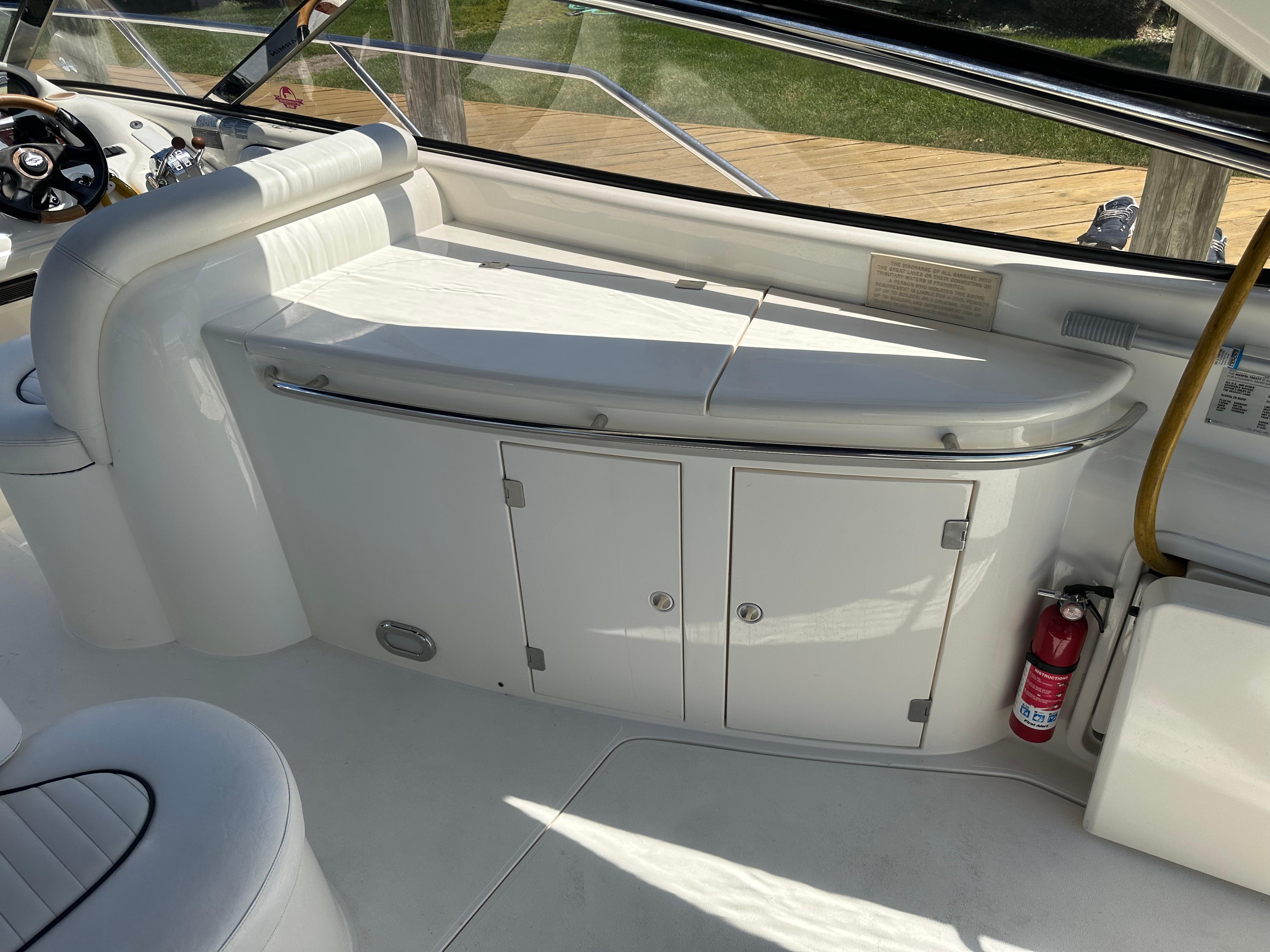 Interior of 1997 Sunseeker Camargue 47 yacht with white seating and storage cabinets.