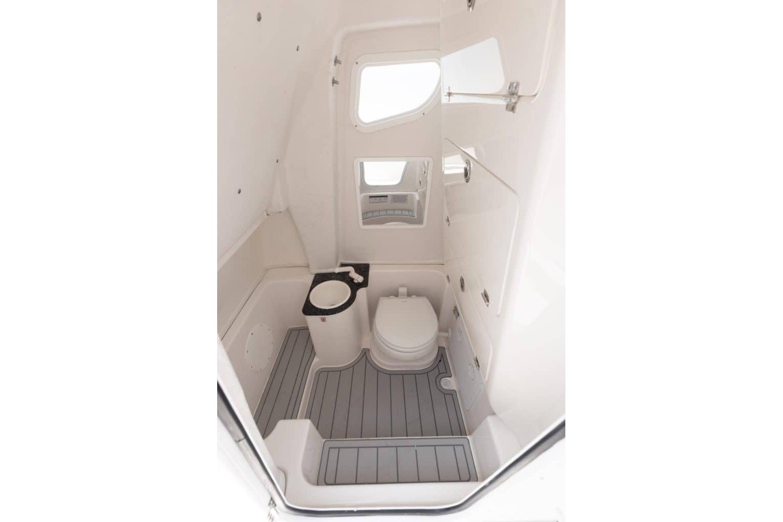 Interior of 2027 Sea Fox 268 Commander boat bathroom with toilet and window.