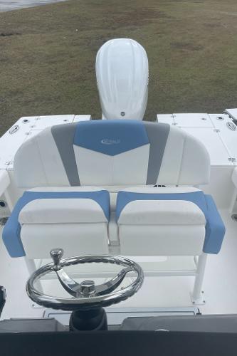 2026 Robalo 246 Cayman boat interior with blue and white seating and steering wheel.