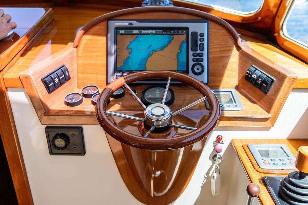 Hinckley Picnic Boat 36 Classic 2000 helm with wooden steering wheel and navigation display.