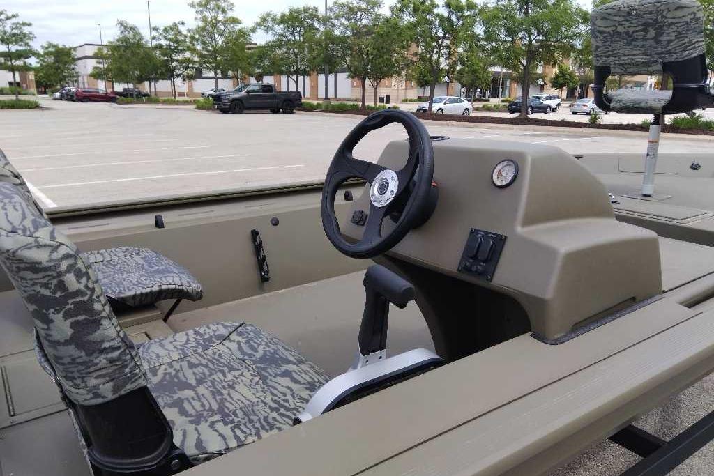 2026 Tracker Grizzly 1754 SC boat interior with camo seats and steering console.