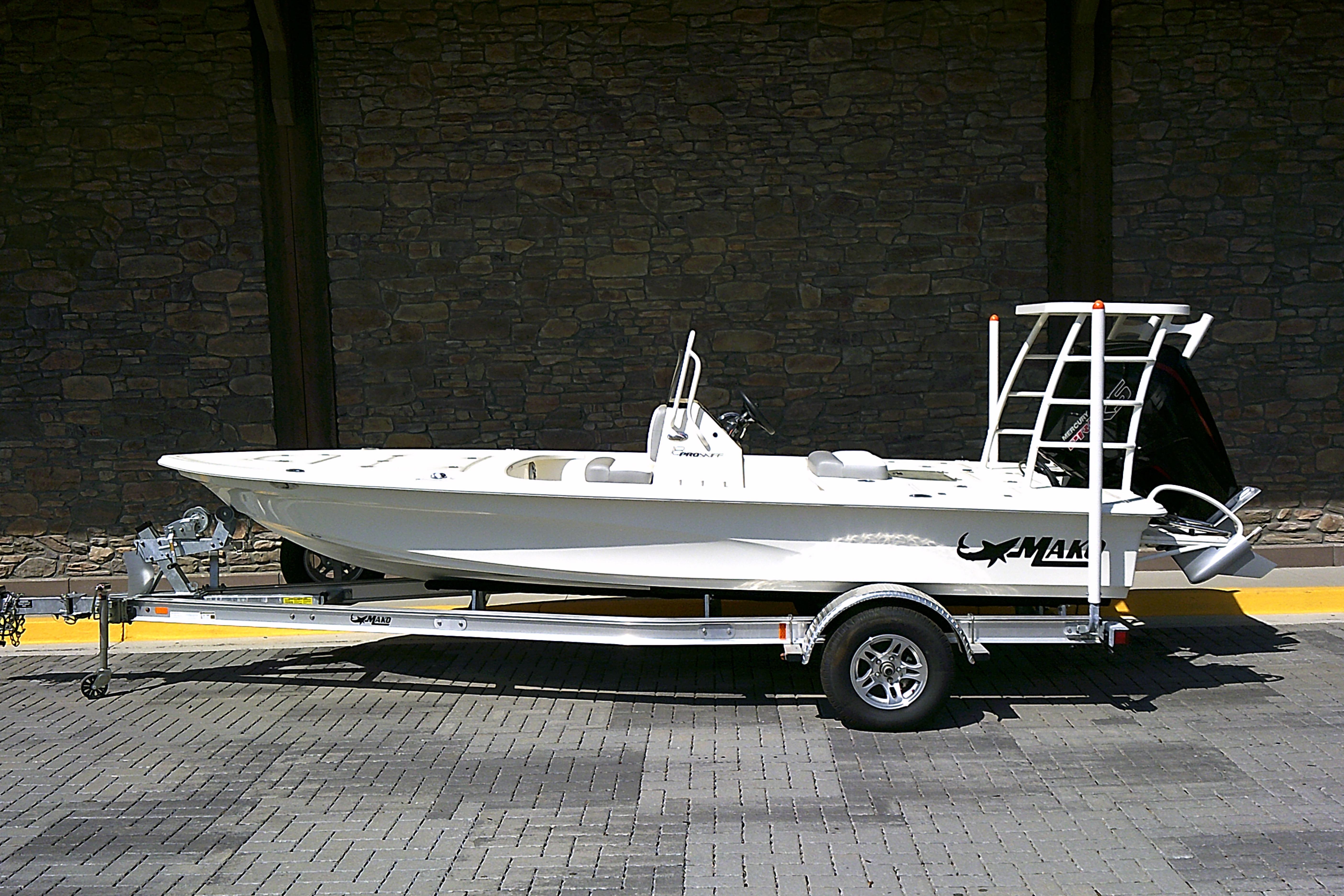 2026 Mako 18 Pro Skiff boat on trailer, parked on paved surface.