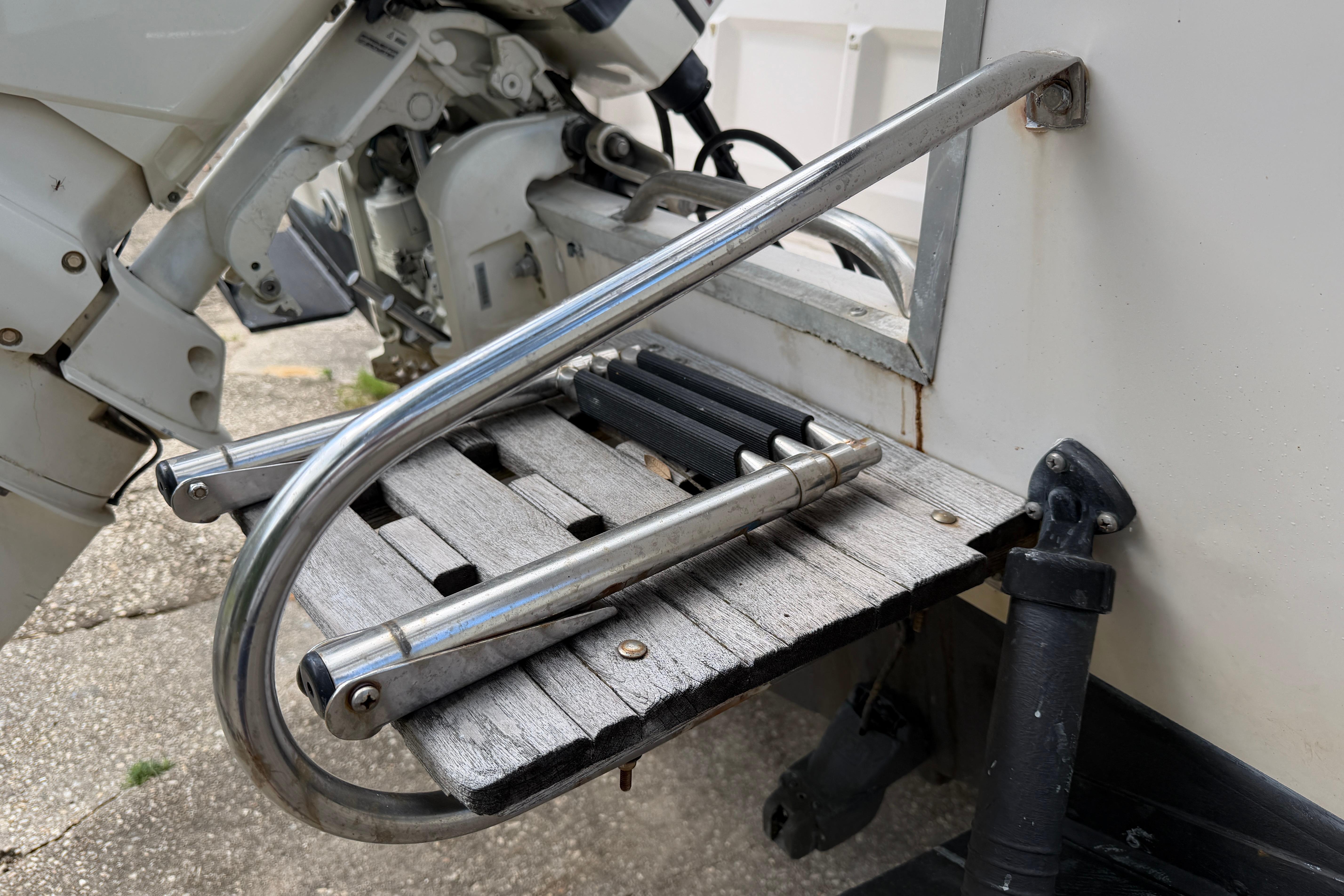 1987 Grady-White Seafarer 226 boat ladder and motor detail, showcasing stainless steel and wood elements.
