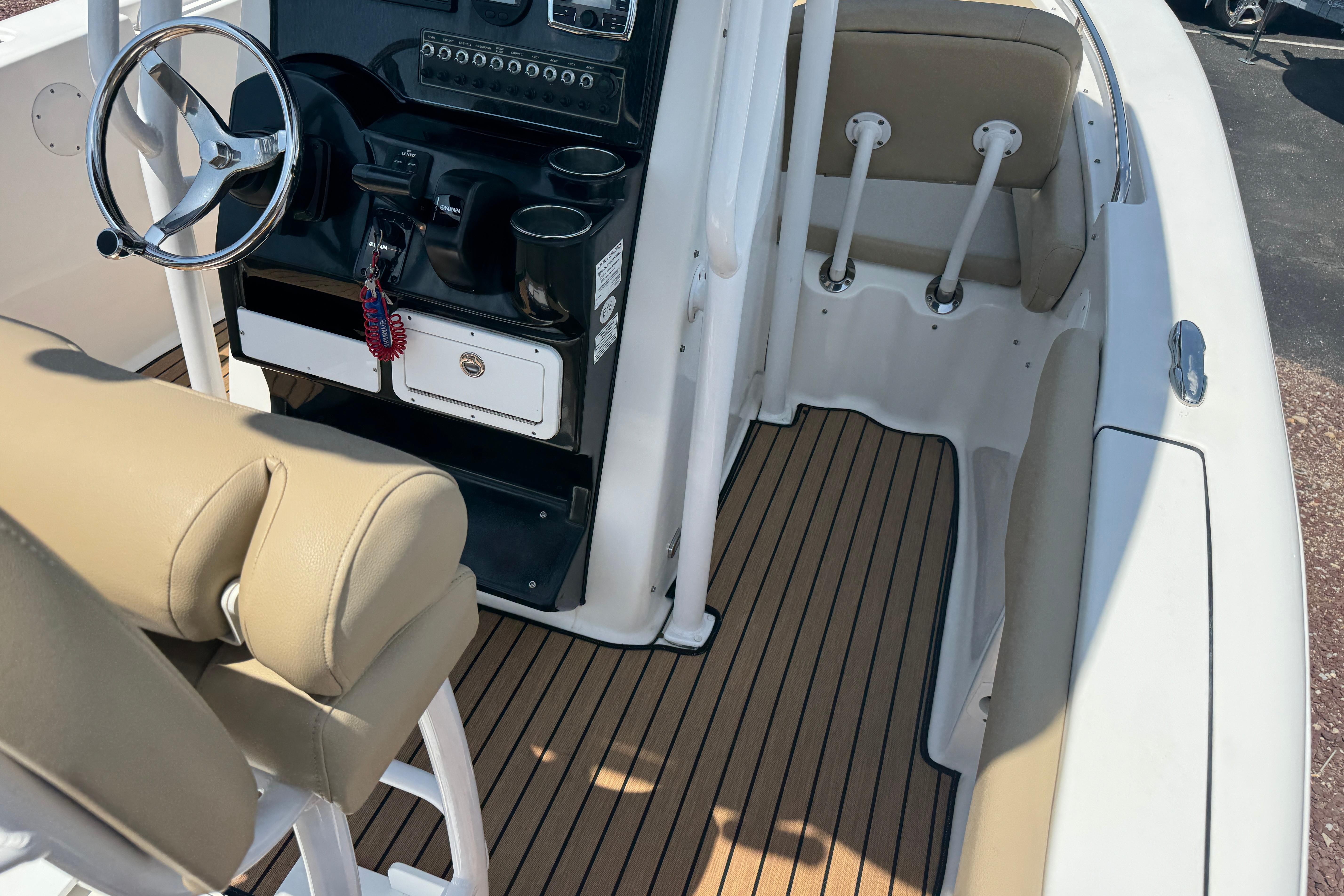 2016 Tidewater 230 LXF boat interior with steering wheel and cushioned seating.