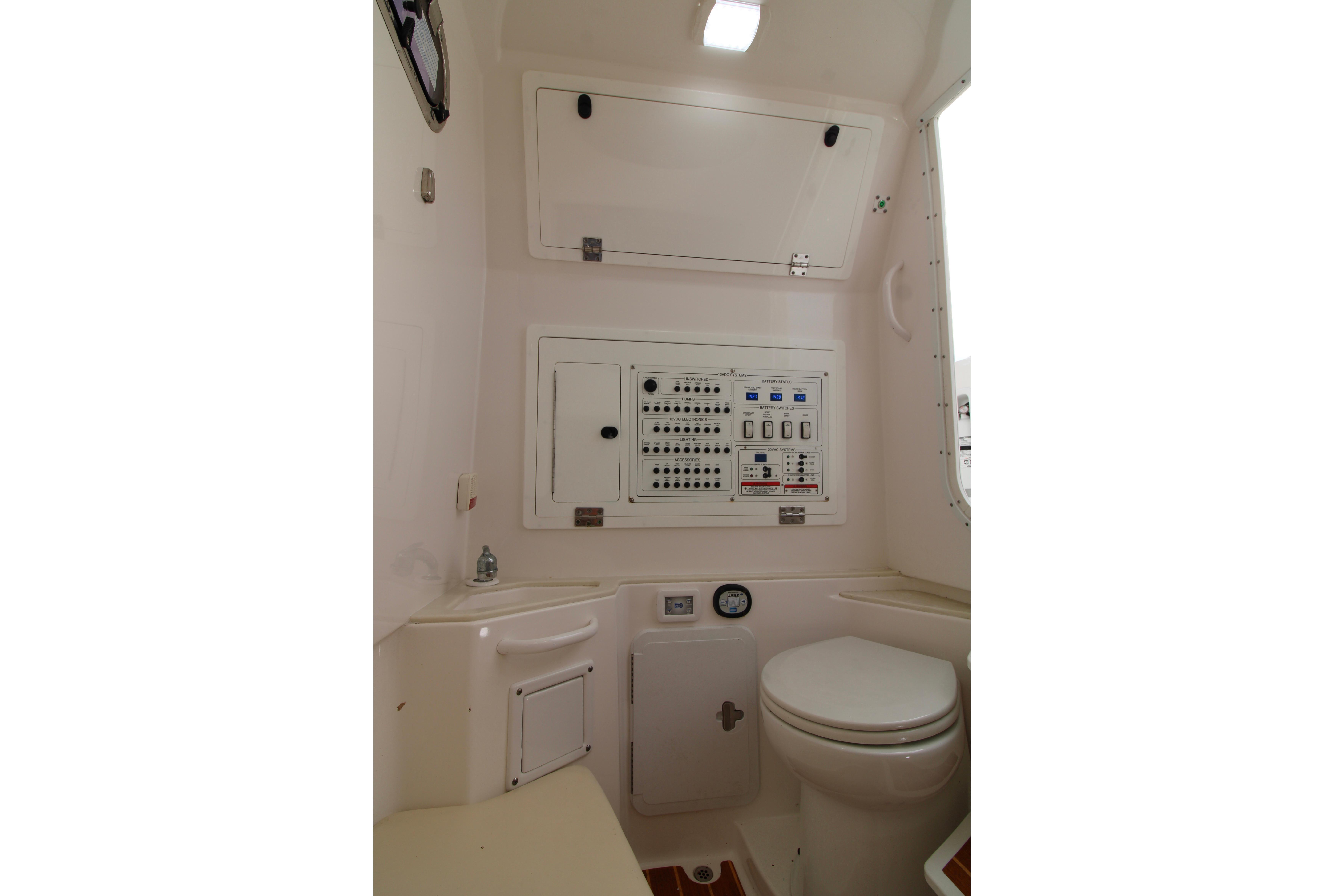 Interior of 2022 Edgewater 280CC boat featuring control panel and marine toilet.