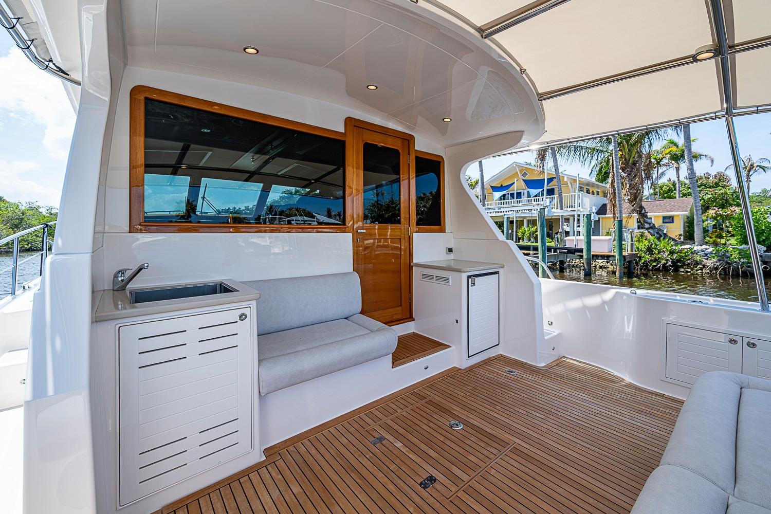 2024 Grand Banks 44 Eastbay yacht deck with seating and sink, dockside view.