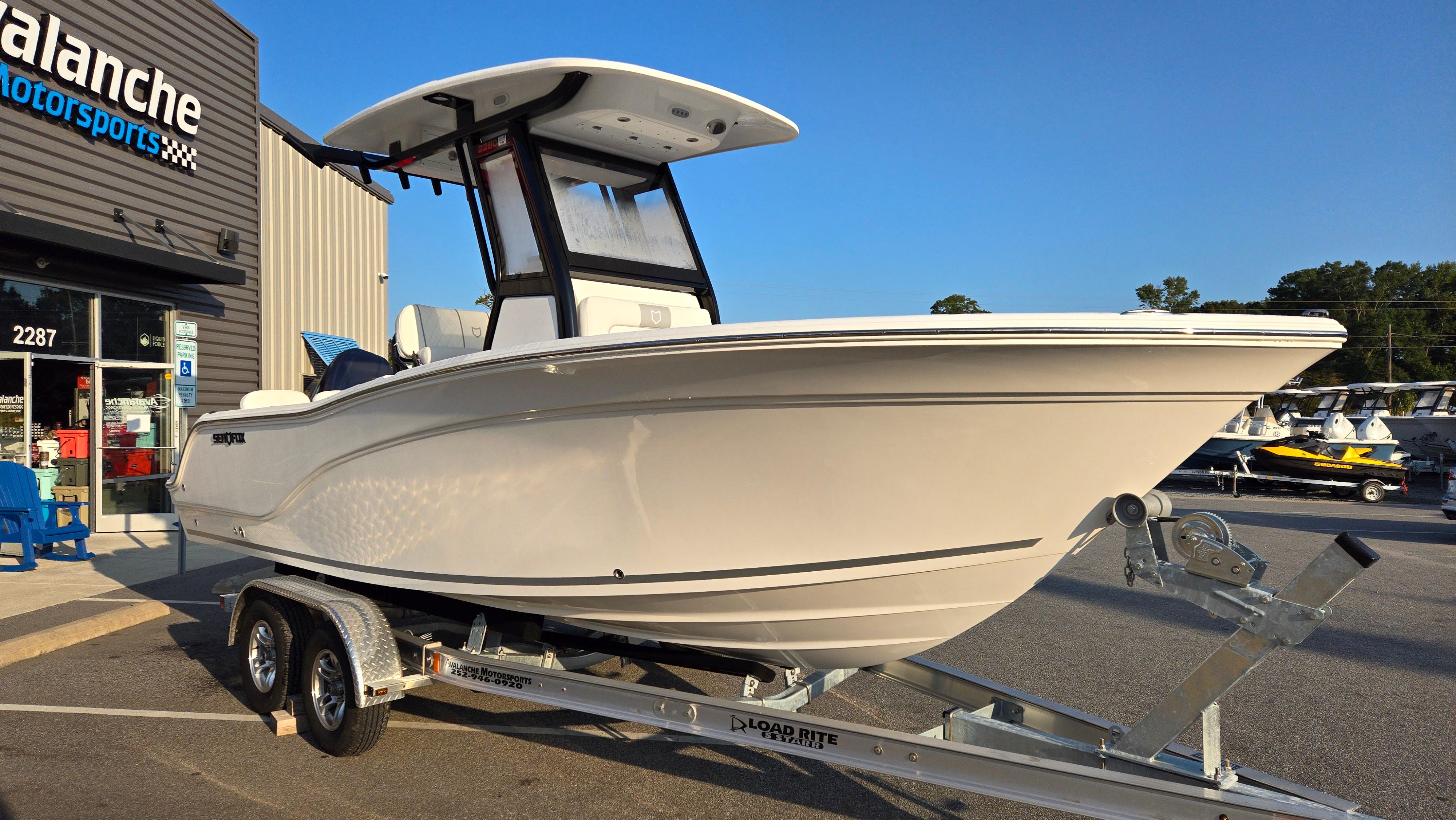 2025 Sea Fox 228 Commander boat on trailer outside dealership.