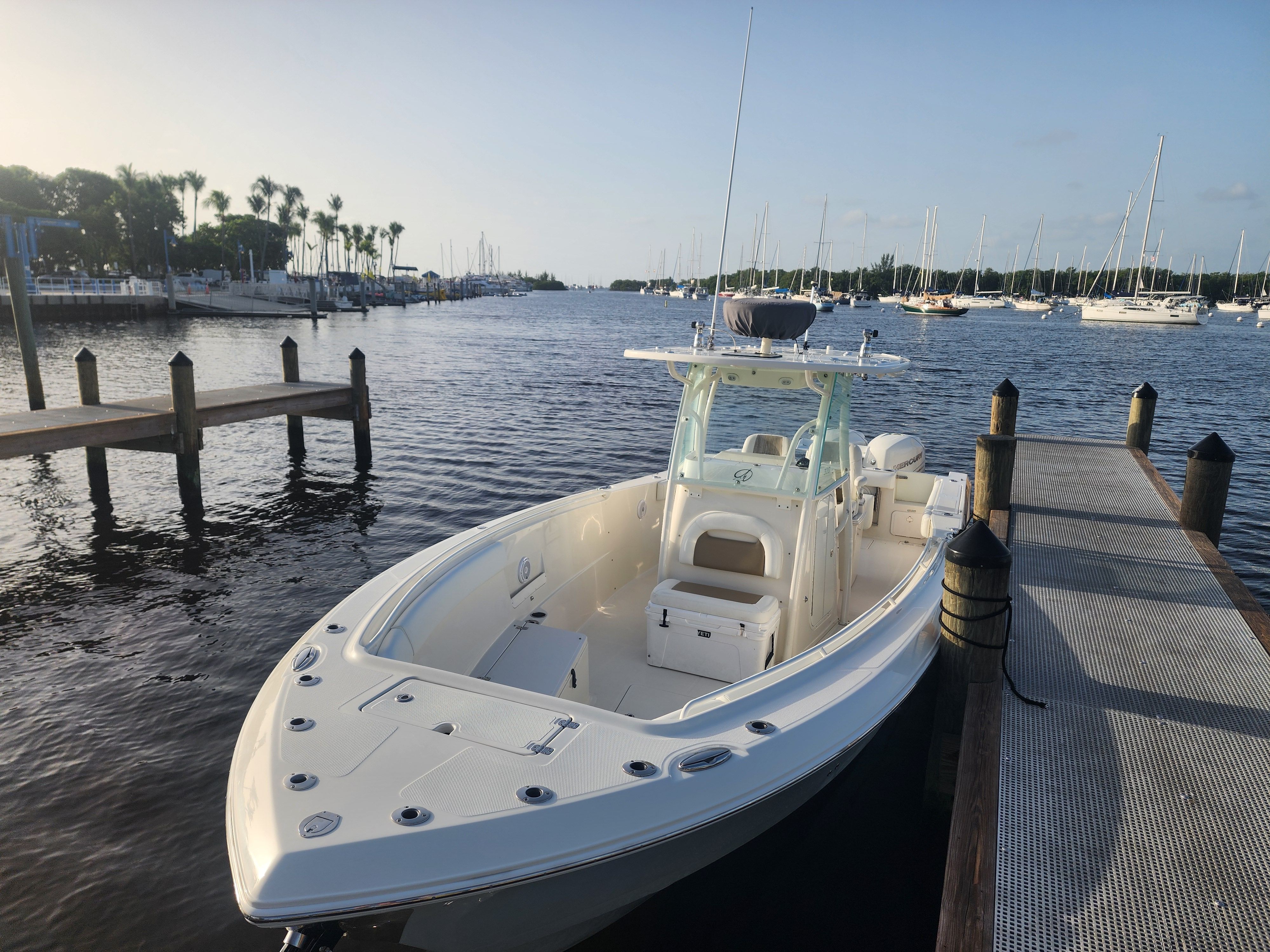 A 2017 Sailfish 320 CC docked. It's a sleek, modern motorboat with a spacious deck.