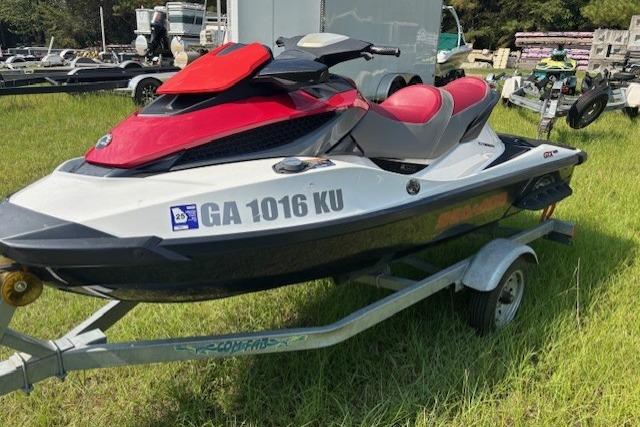2010 Sea-Doo GTX 155 jet ski on trailer, red and white, parked on grass.