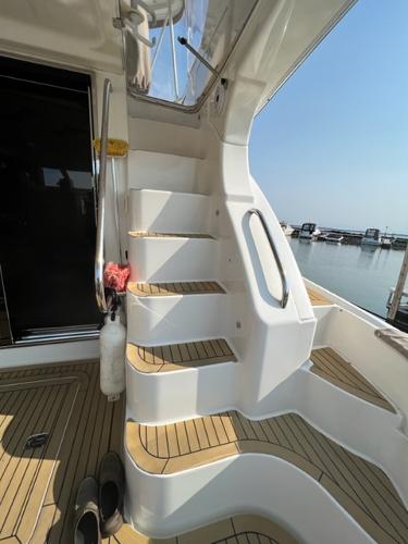 Staircase on a 2009 Ovation 52 yacht with marina view.
