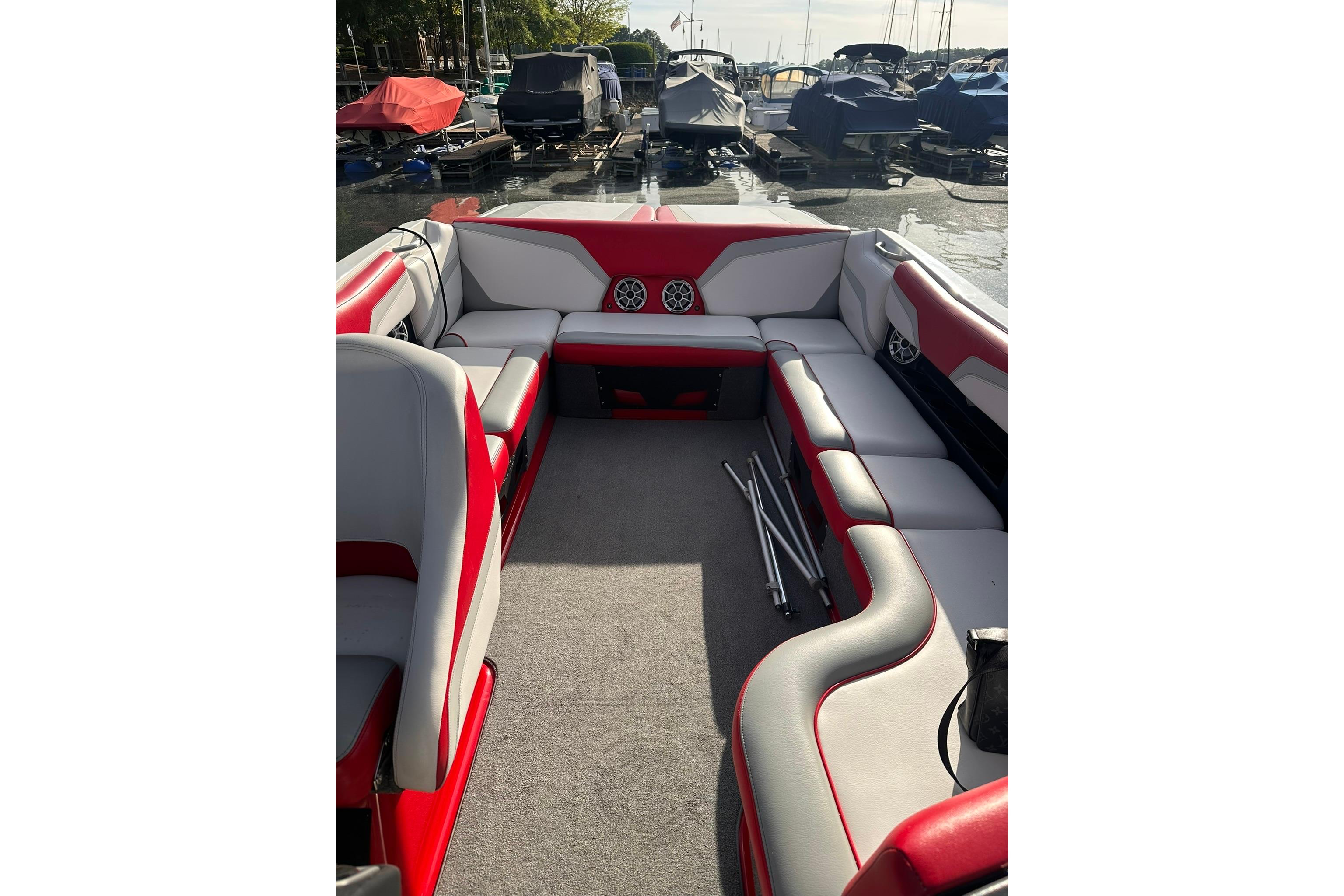 2017 Axis T23 boat interior with red and gray seating, docked at a marina.