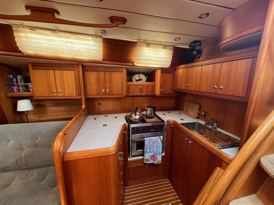 Interior of 2001 Najad 460 yacht with wooden cabinetry and compact kitchen area.