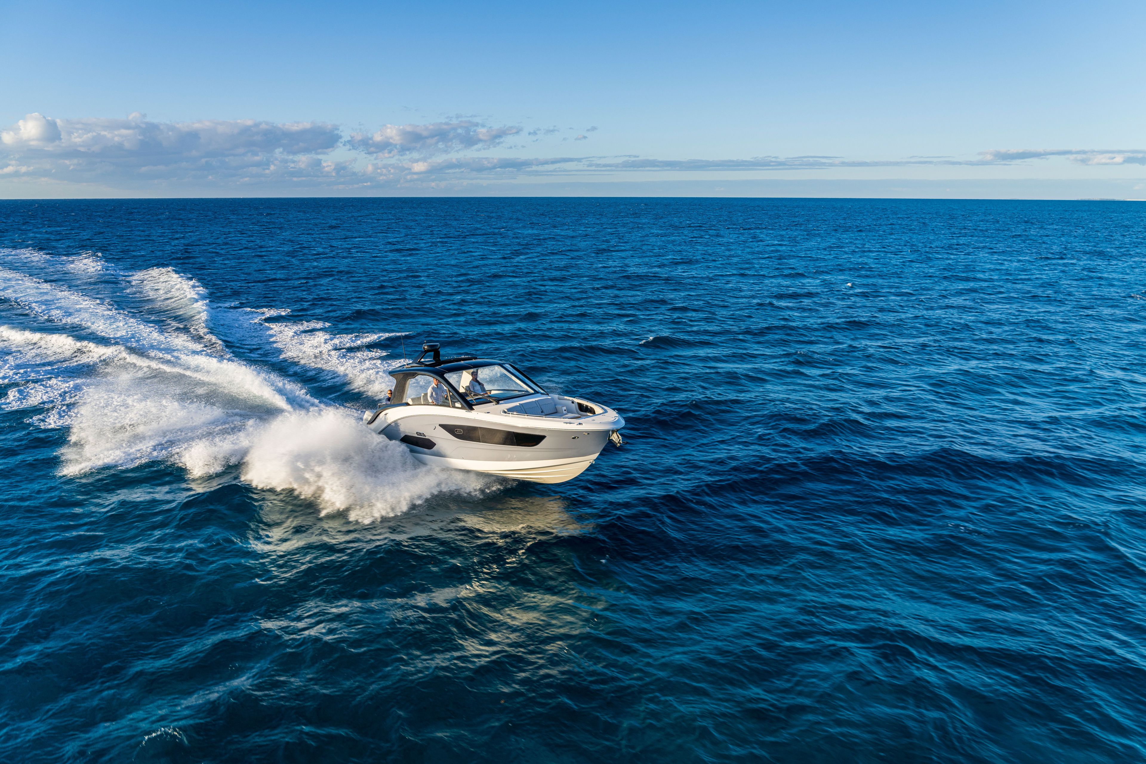 A 2026 Sea Ray Sundancer 370 Outboard speeding across the open sea.