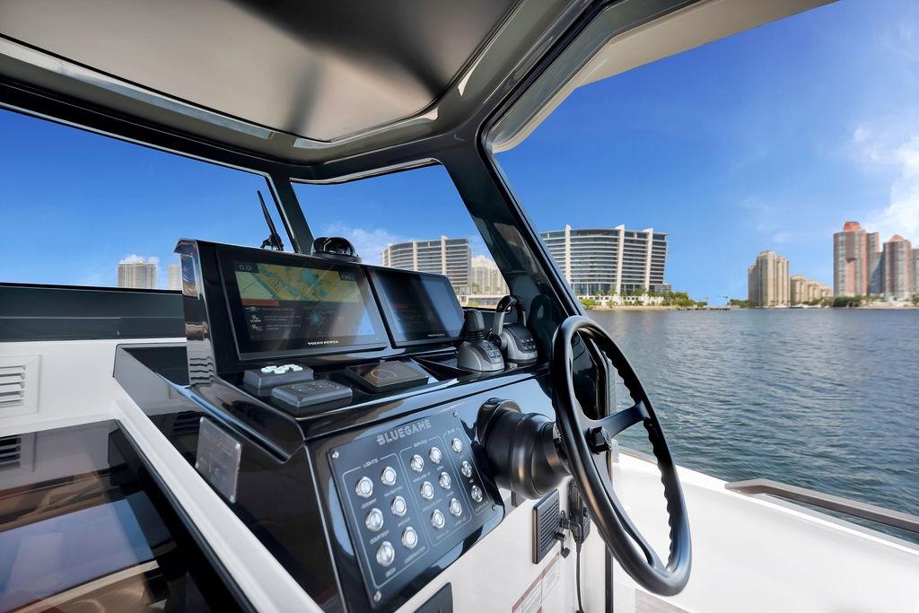 Interior view of 2021 Bluegame BG 42 yacht helm with cityscape background.