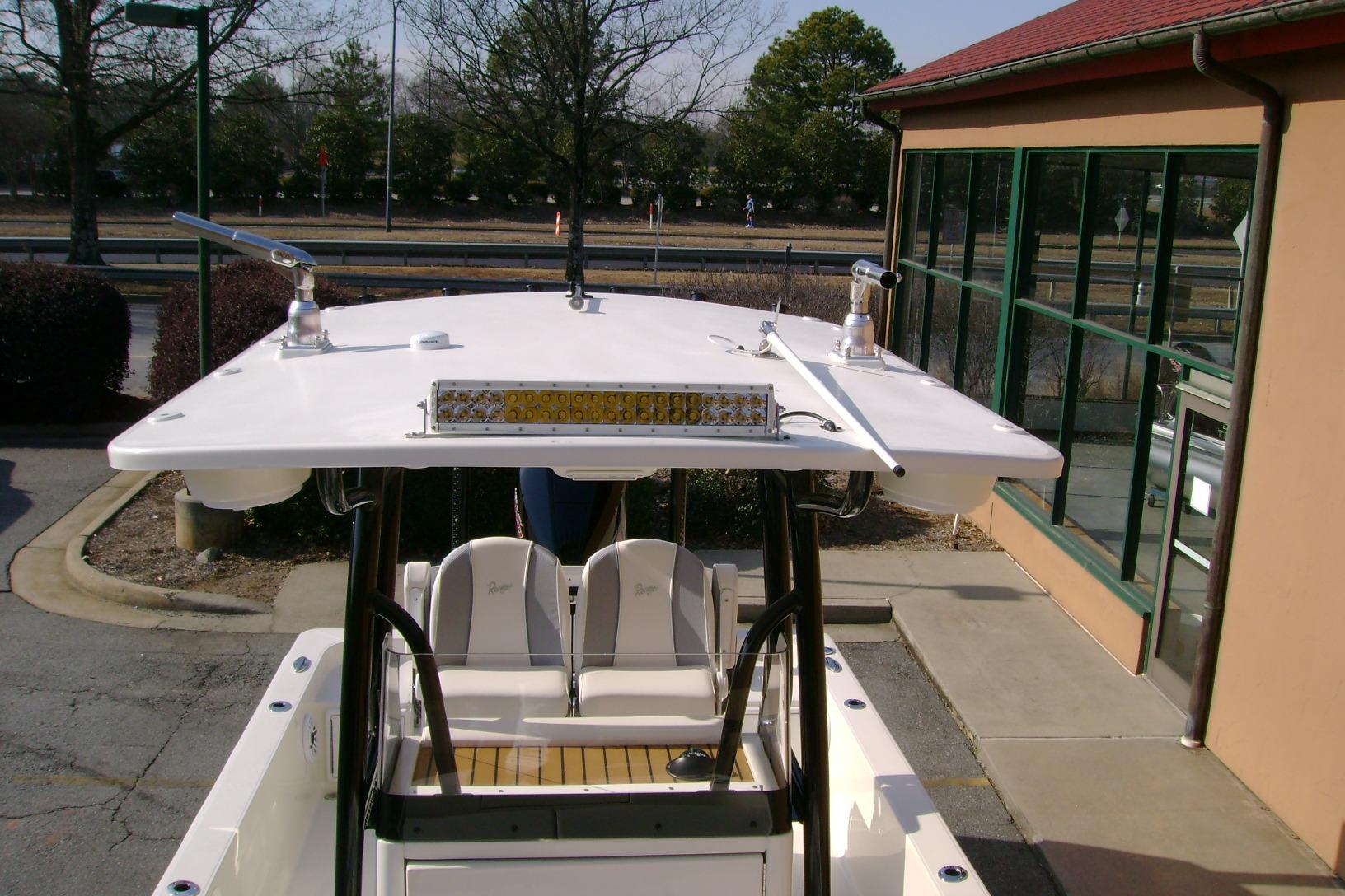 2026 Ranger 2360 Bay boat with T-top and seating, parked near a building.