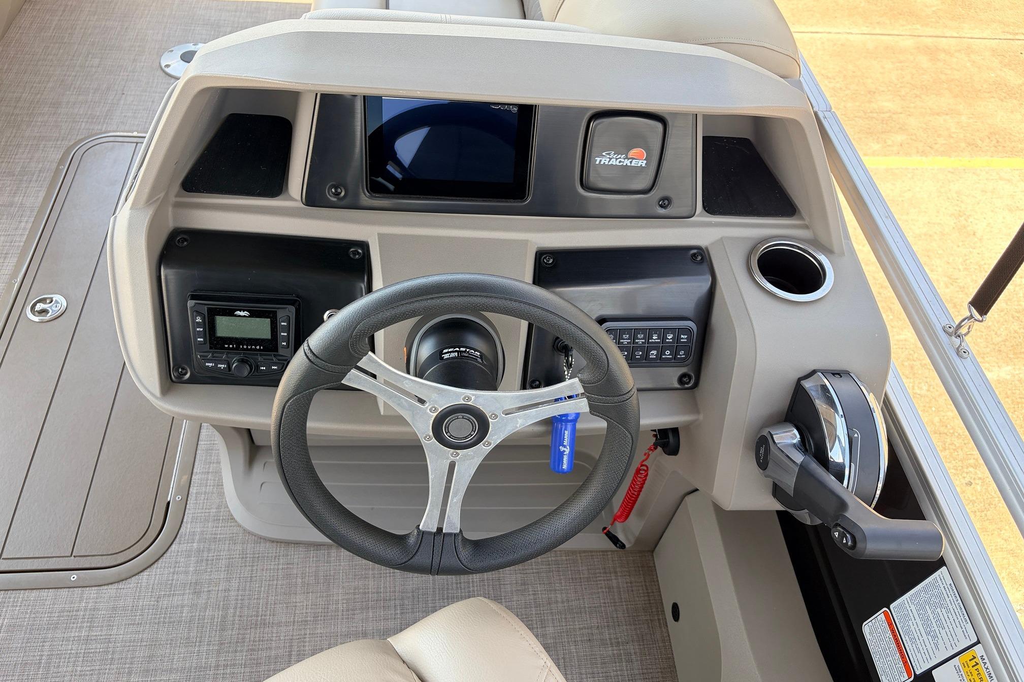 2024 Sun Tracker SportFish 22 XP3 boat dashboard with steering wheel and controls.