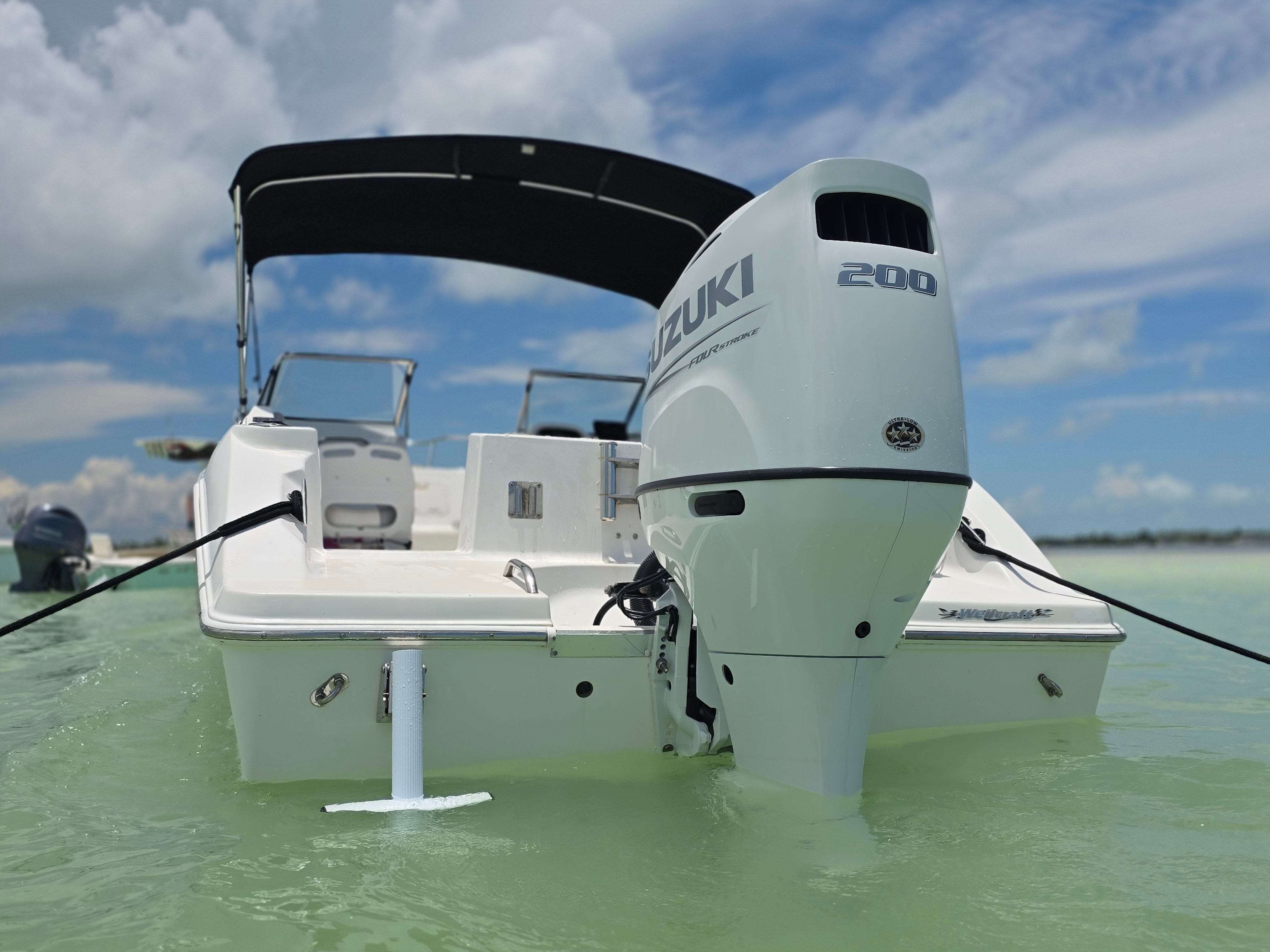 Wellcraft Sportsman 2001 boat with Suzuki engine on water.