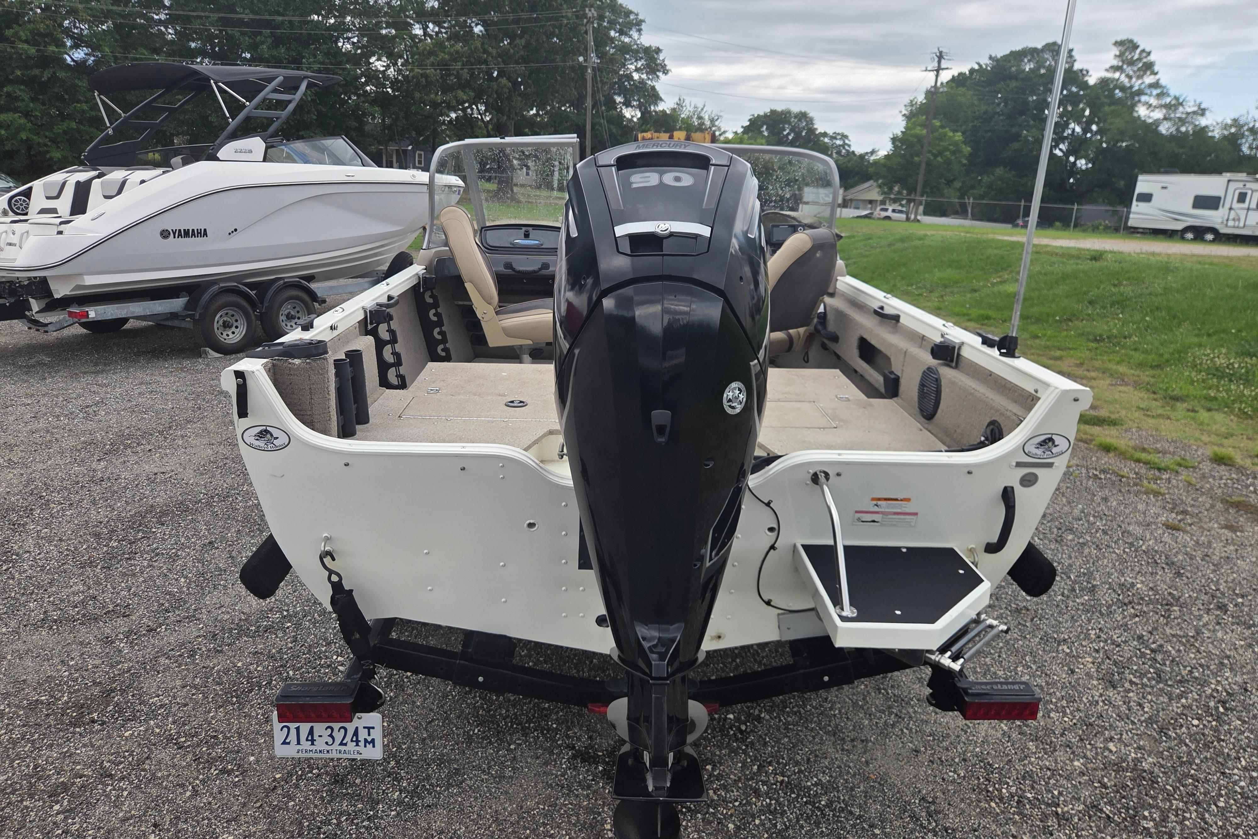 2016 Crestliner 1650 Fish Hawk SC boat with outboard motor, parked on gravel.