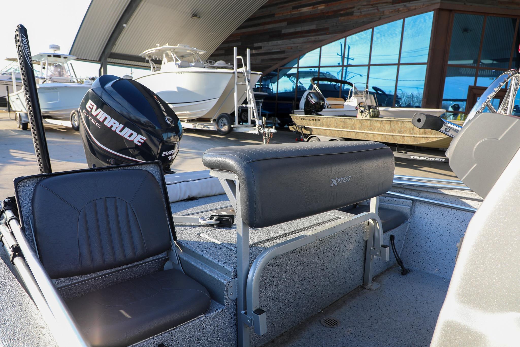 2019 Express 18 boat interior with Evinrude motor, parked near other boats.