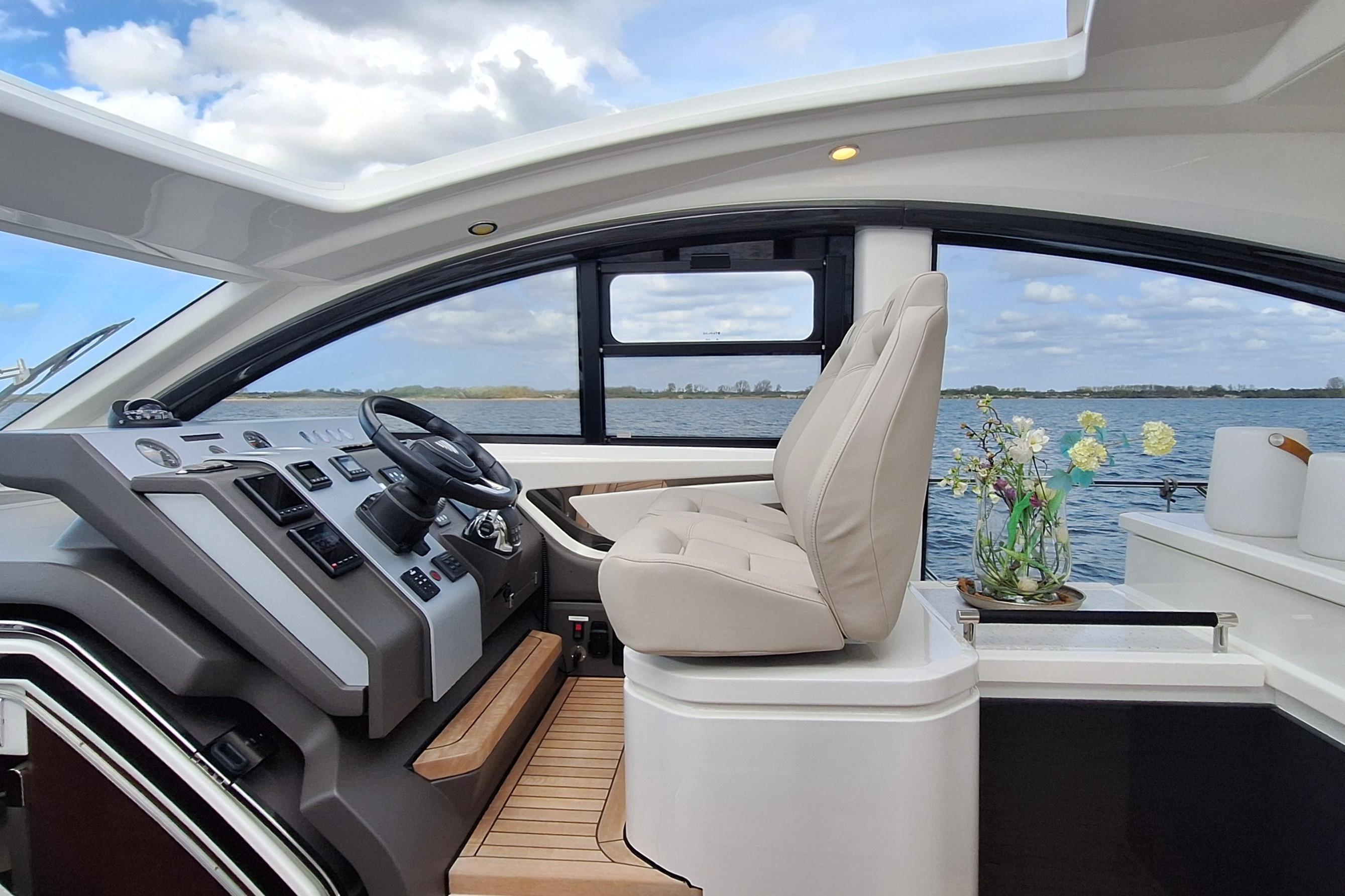 Interior of 2022 Fairline Targa 53 yacht, featuring helm and luxurious seating.