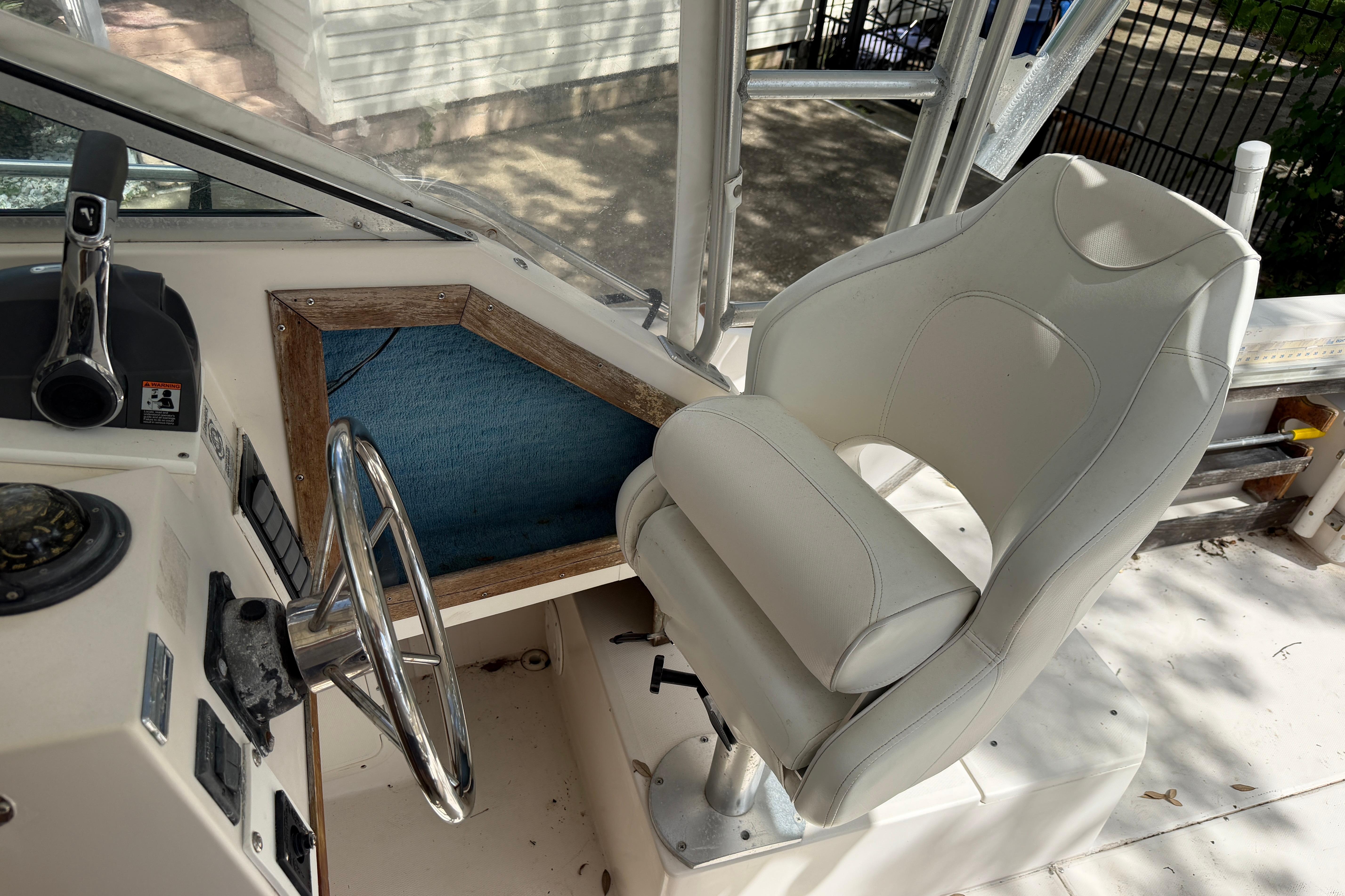 1987 Grady-White Seafarer 226 boat cockpit with steering wheel and white captain's chair.