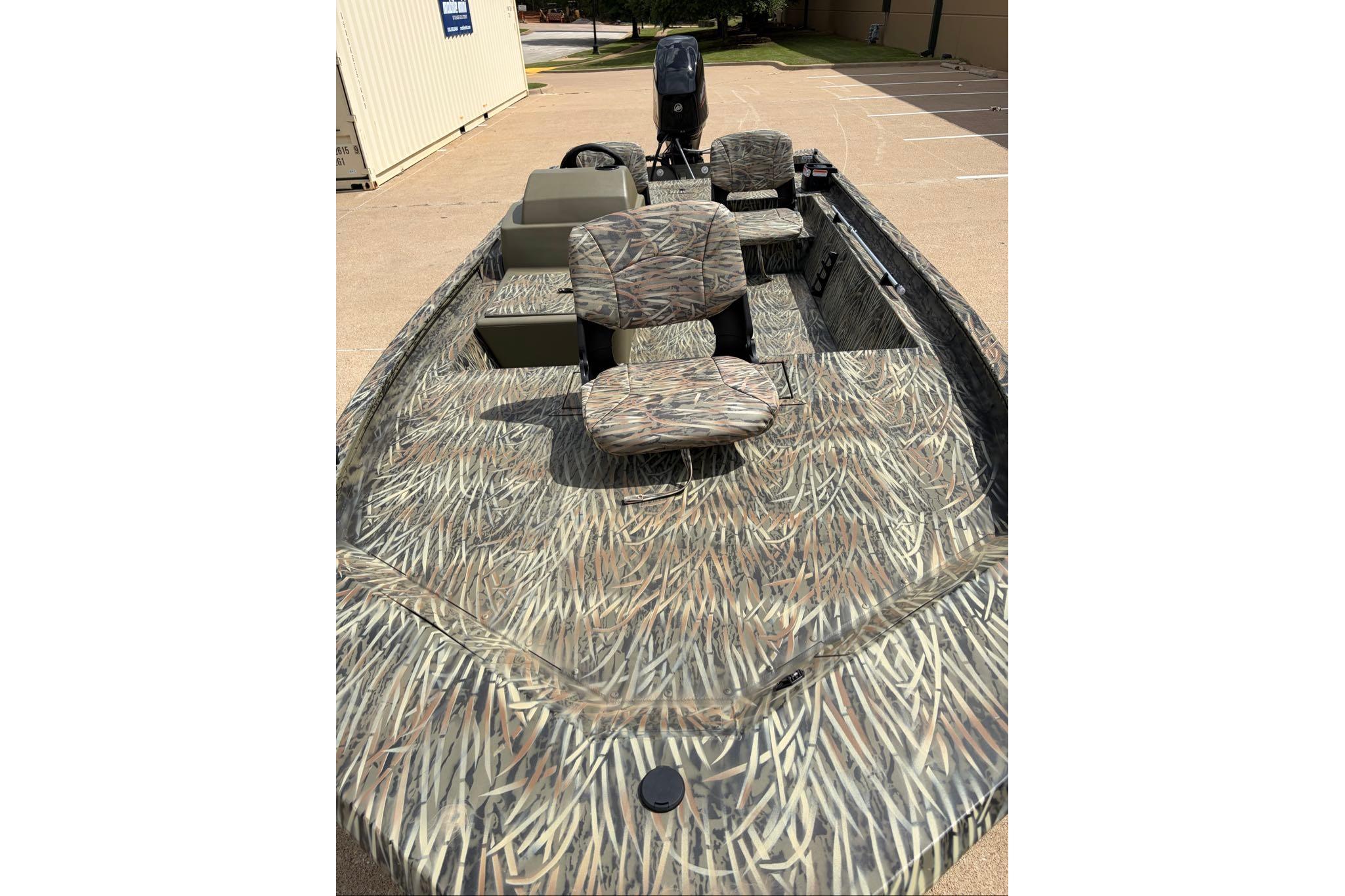 2026 Tracker Grizzly 1754 SC boat with camouflage pattern and seating, parked outdoors.