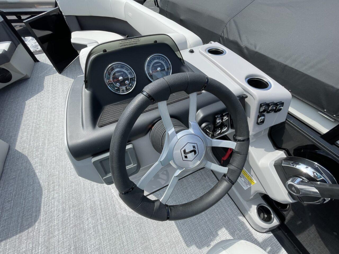 2026 Harris Cruiser 230 boat dashboard with steering wheel and gauges.