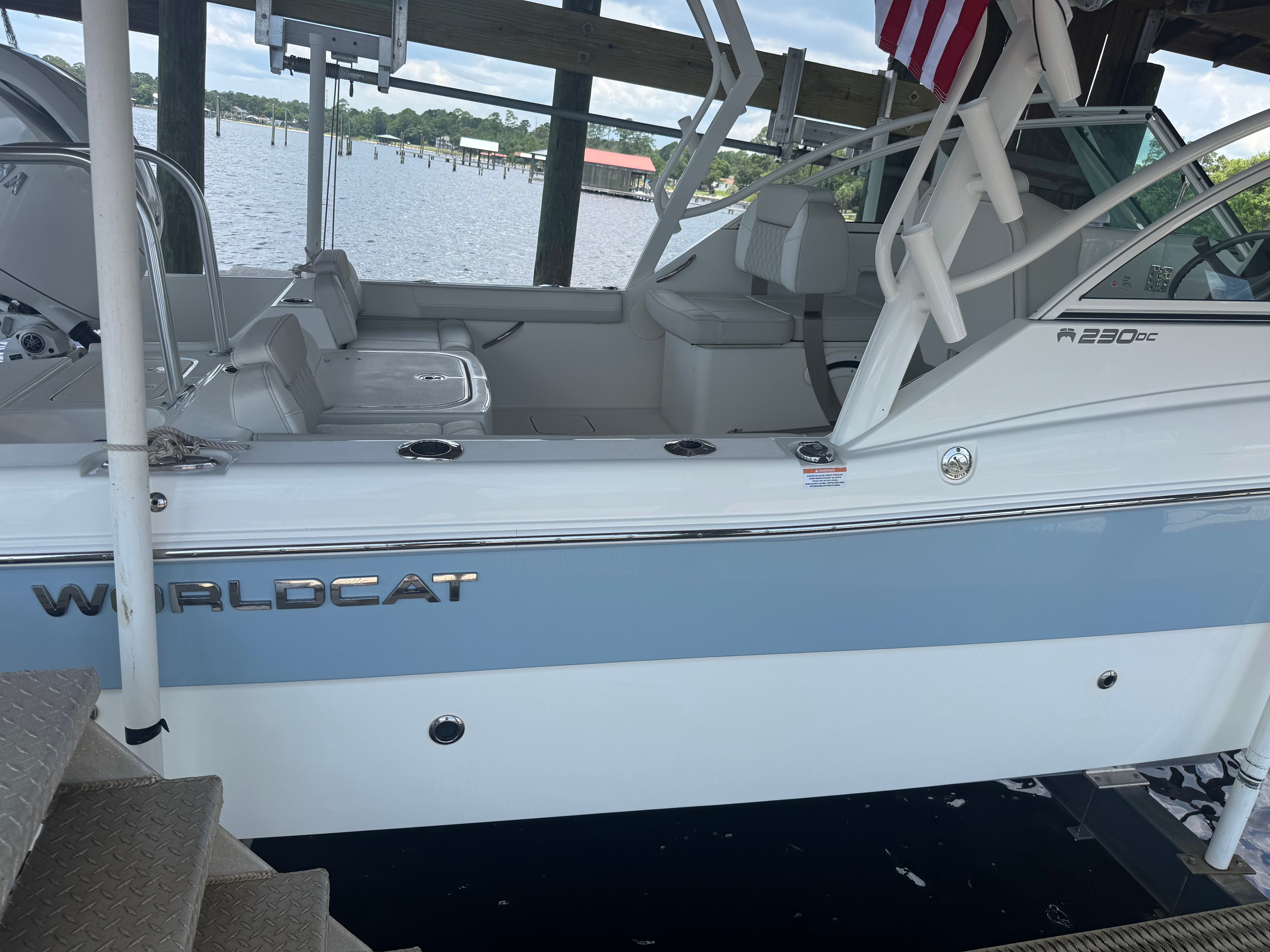 2025 World Cat 230 DC docked by the water.