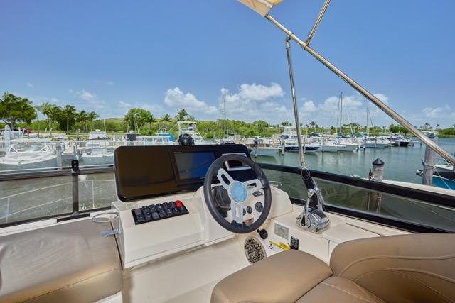 2015 Carver C34 Command Bridge helm with marina view, featuring modern controls and comfortable seating.