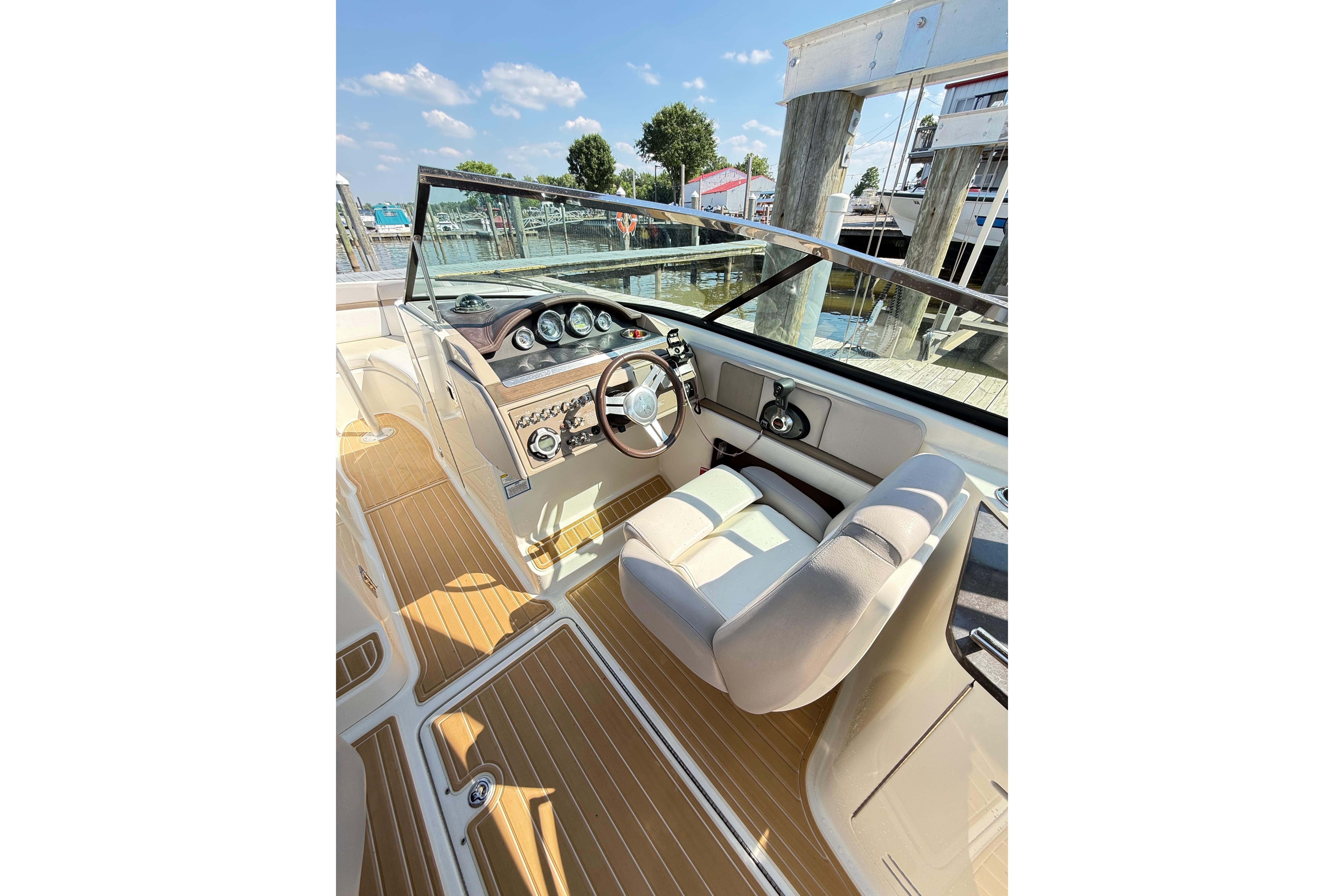 2011 Sea Ray 270 SLX boat cockpit with steering wheel and dashboard, docked at marina.
