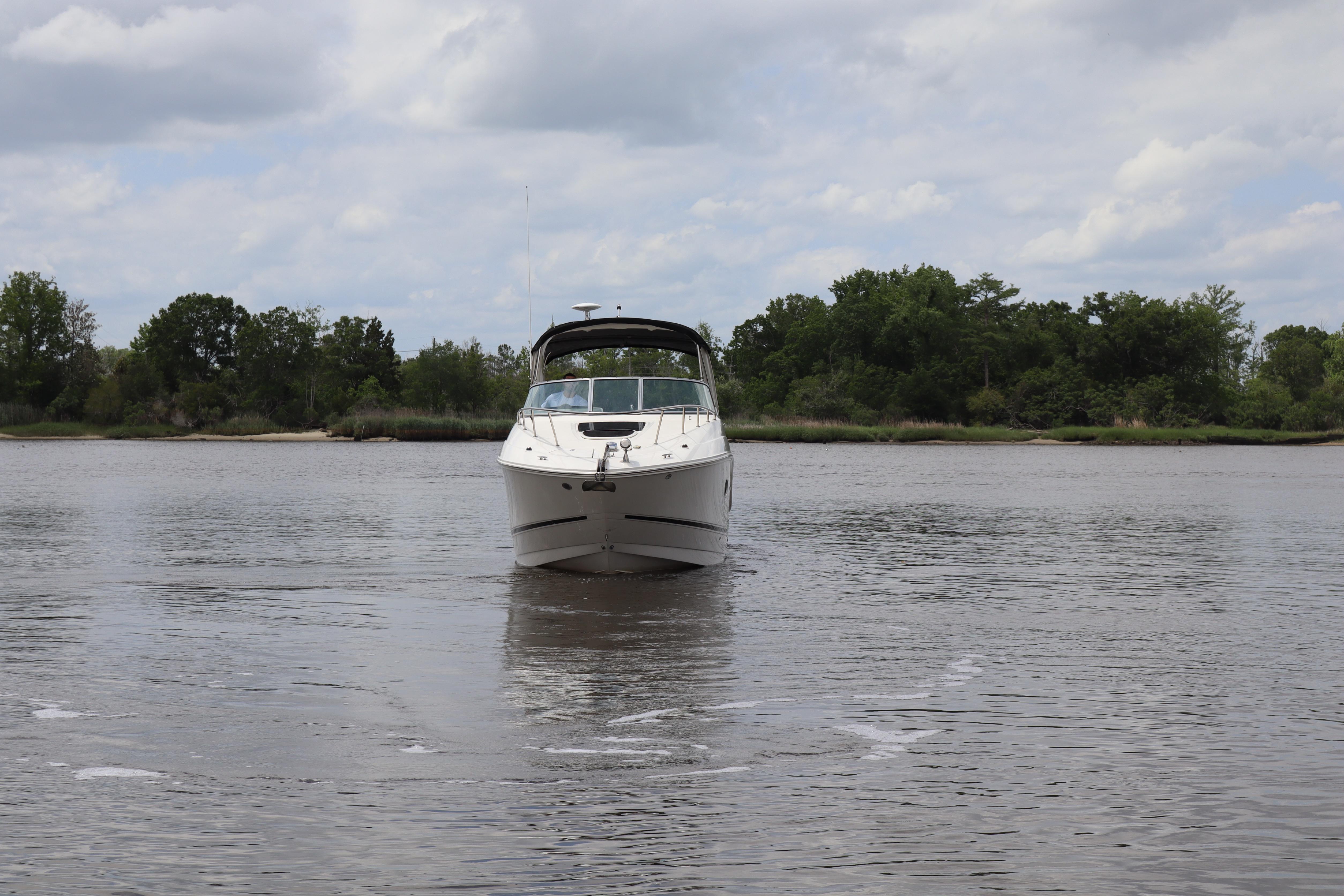 2011 Sea Ray Sundancer 280 boat on calm water with lush green shoreline.