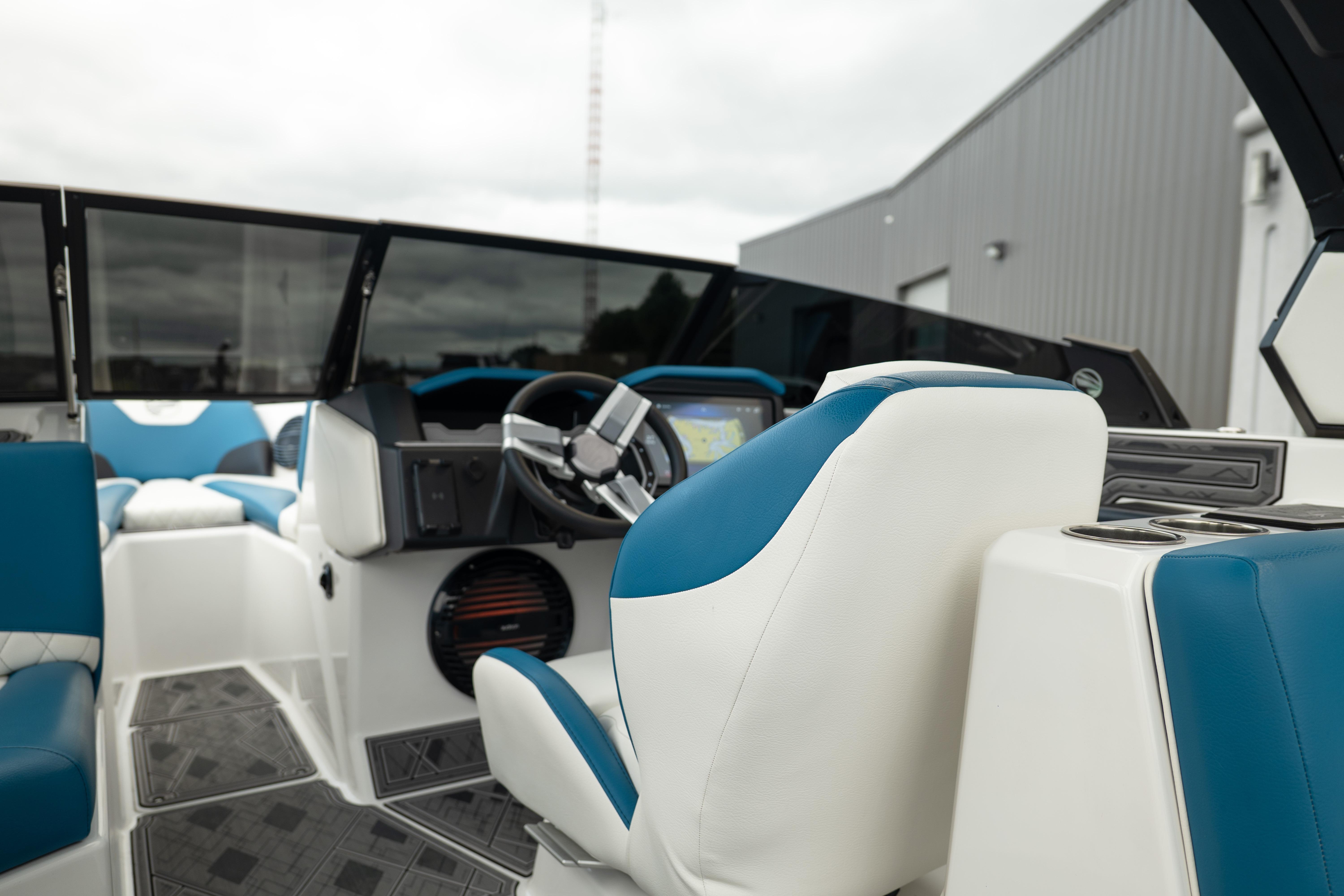 2024 Tigé Z5 boat interior with blue and white seating, modern dashboard, and steering wheel.