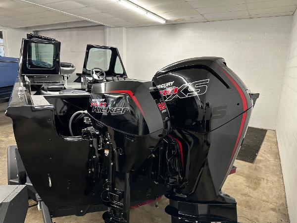 2025 Crestliner 1850 Commander boat with dual Mercury outboard motors in a showroom.