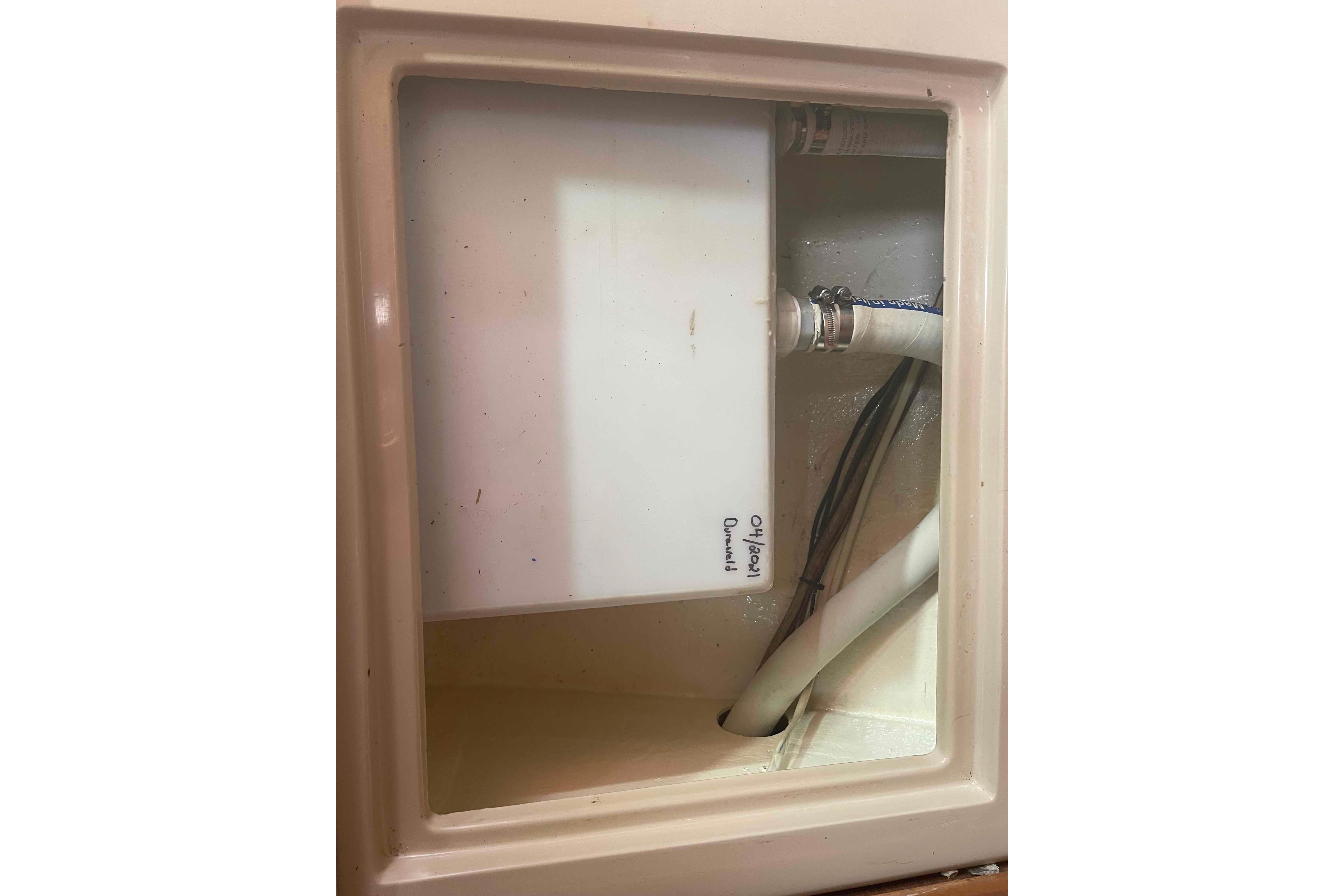 Interior compartment of 1989 Island Packet 35 sailboat with visible plumbing and wiring.