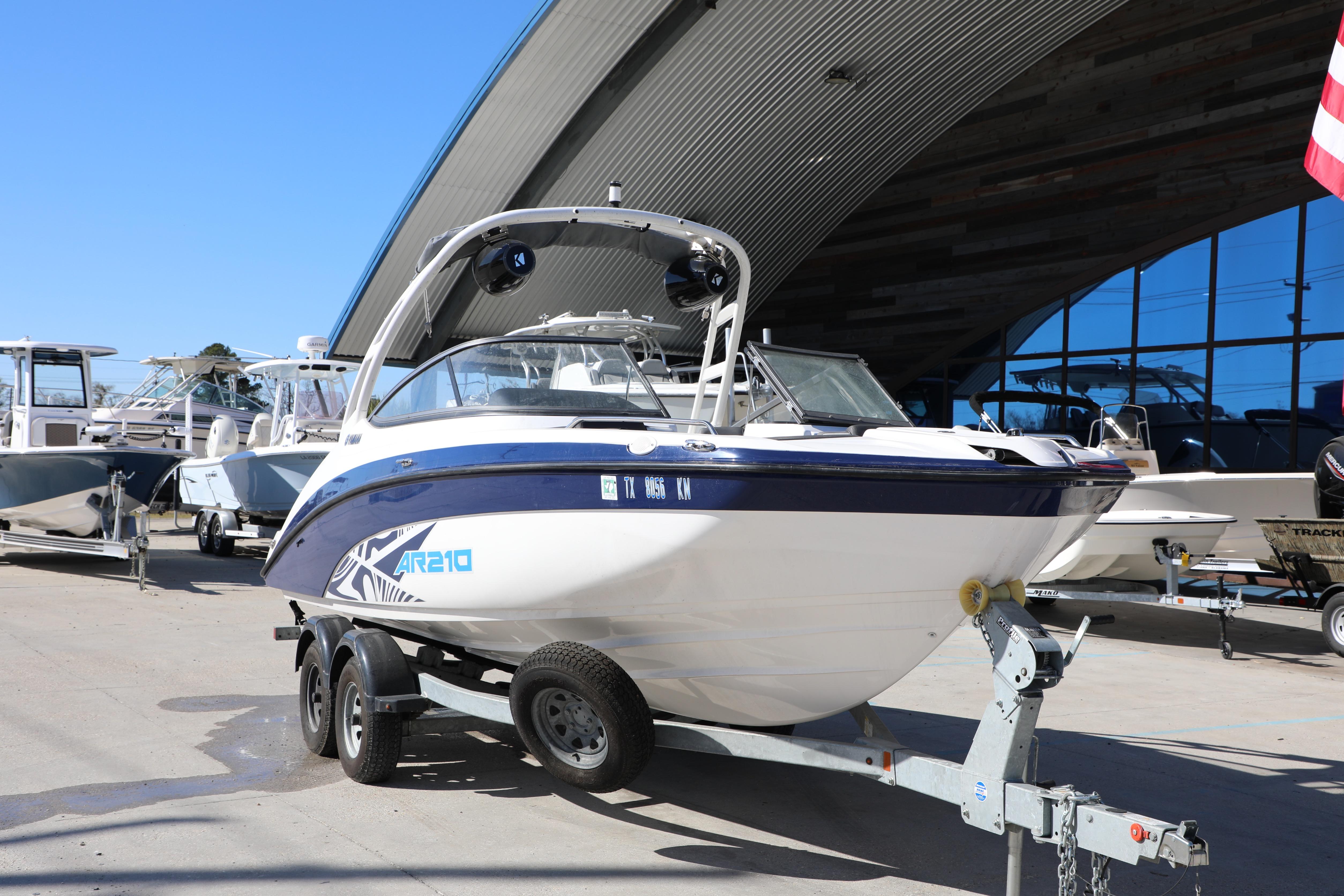 2022 Yamaha Boats AR210 on trailer, parked outdoors near other boats.