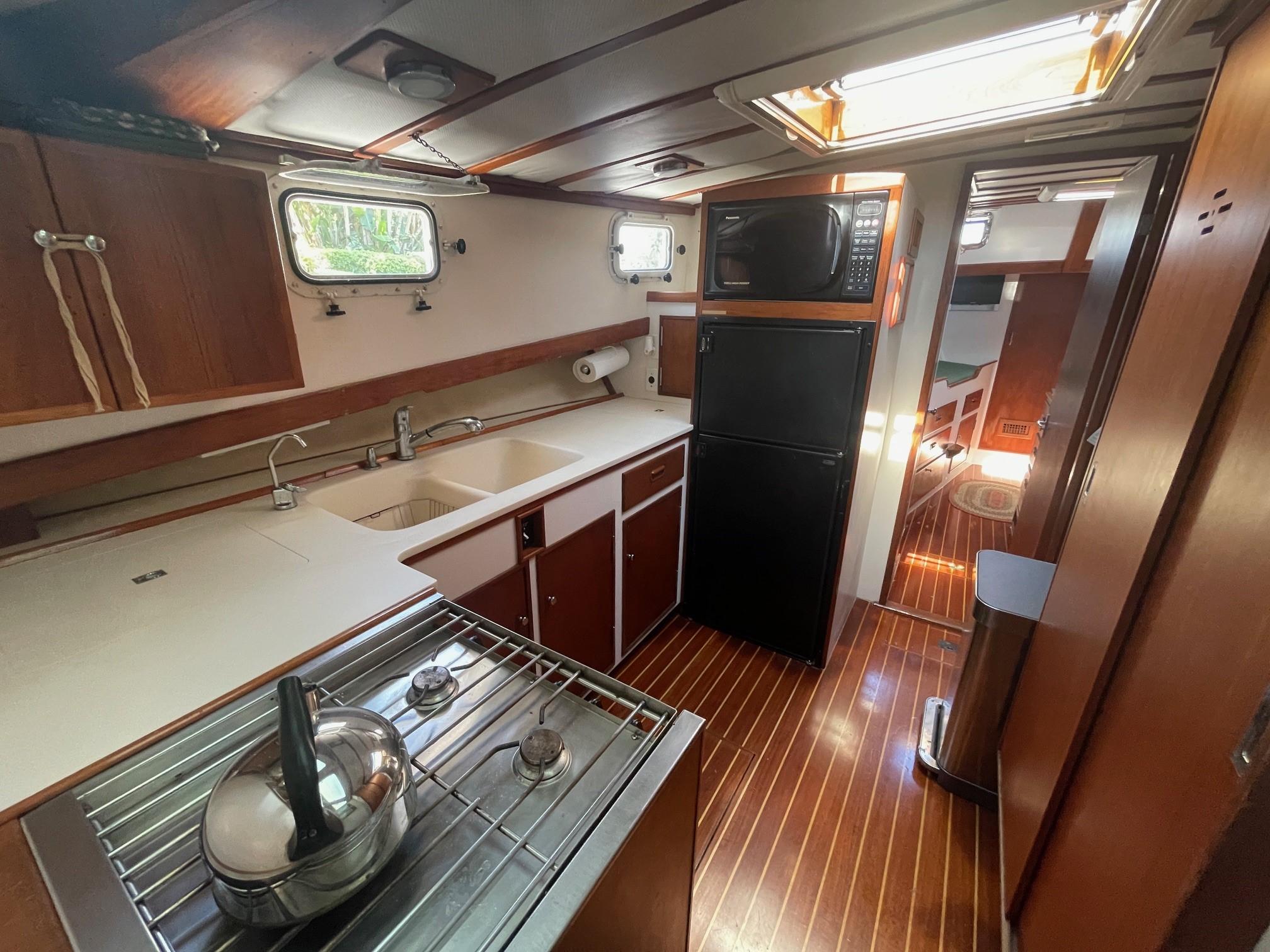 1979 Jarvis Newman Trawler kitchen with stove, sink, fridge, and microwave.