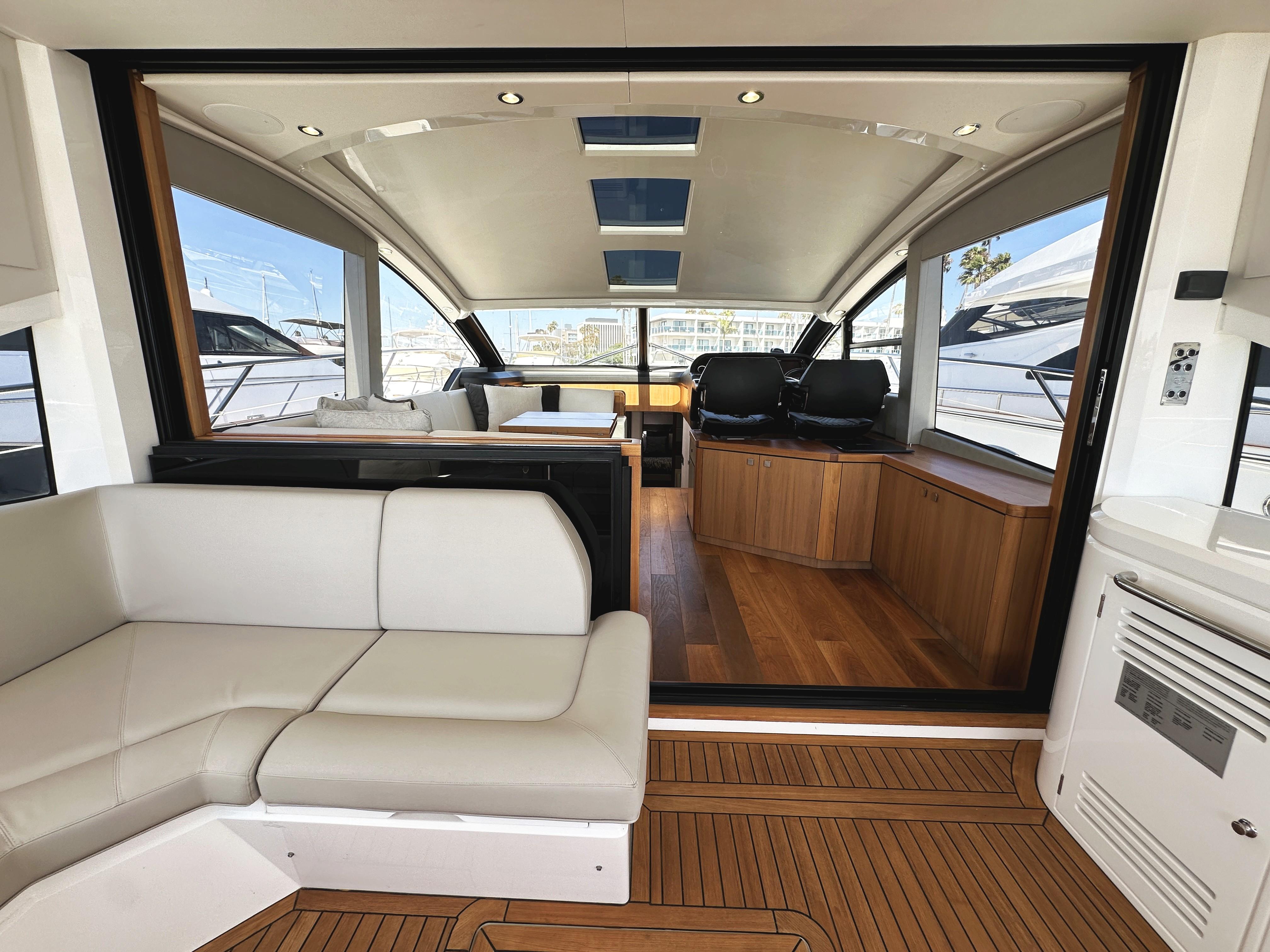 Luxurious interior of 2019 Sunseeker Predator 57 yacht with modern seating and wood accents.