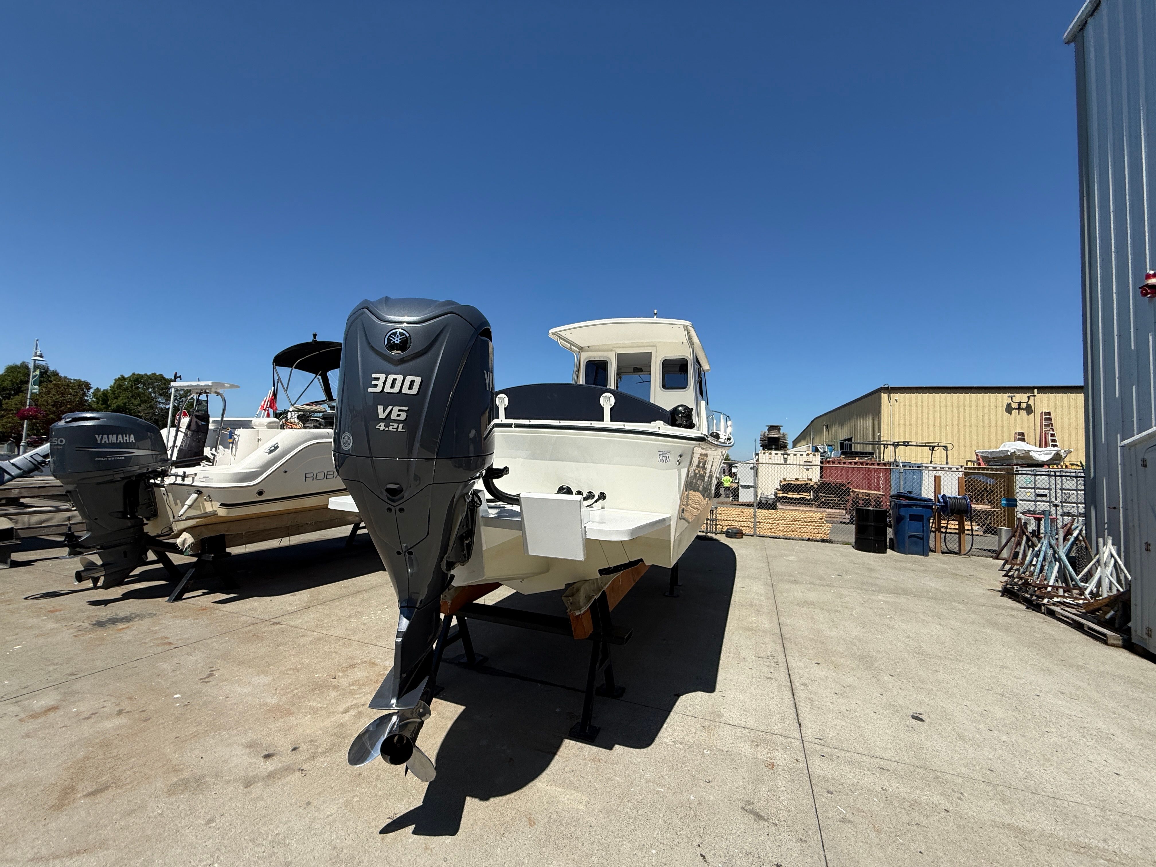 A 2015 Steiger Craft 255 Chesapeake boat is on dry dock, next to other boats.