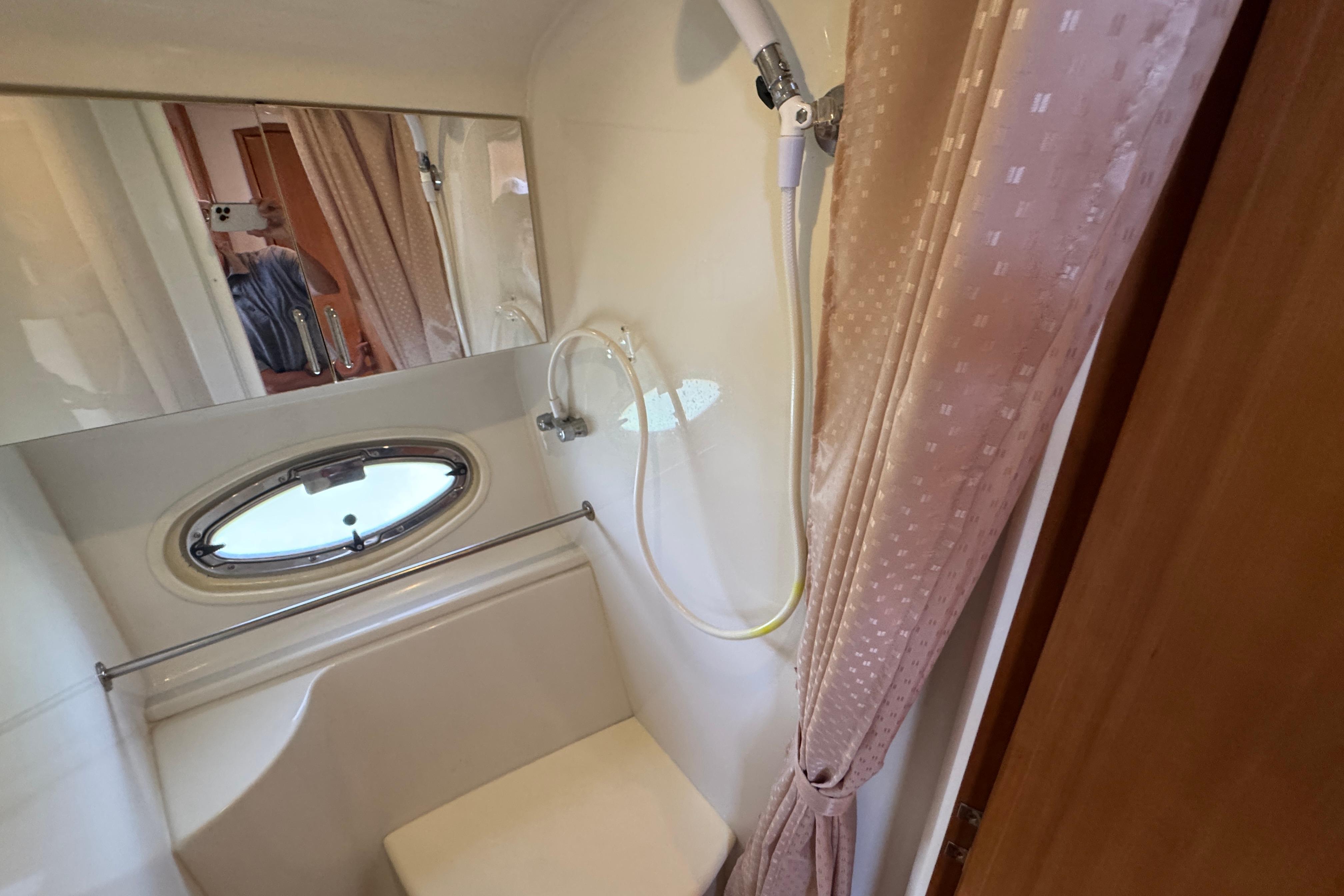 Bathroom interior of 2002 Carver 396 Motor Yacht with shower and oval window.